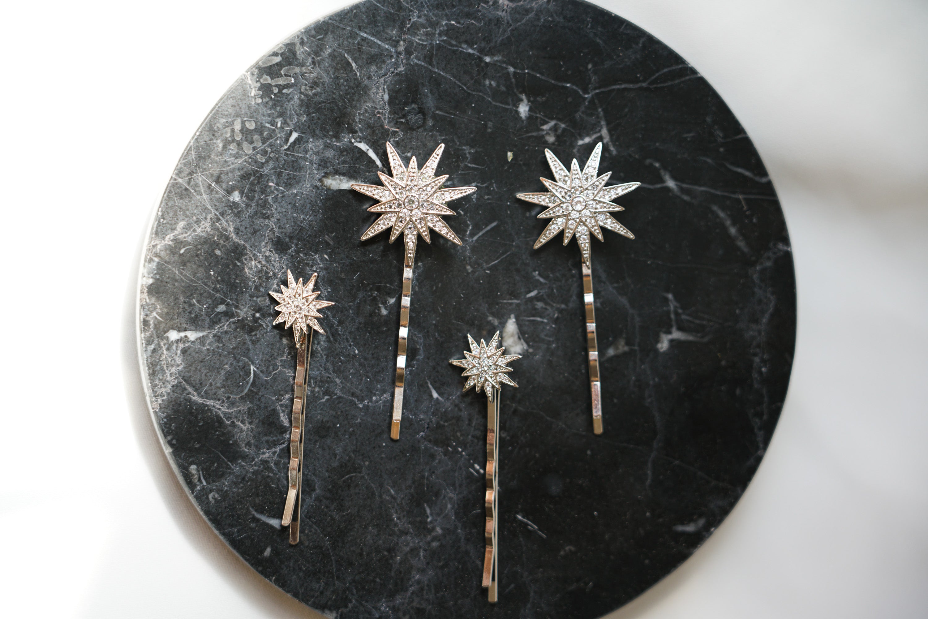 pince en or avec des étoiles de deux tailles différentes