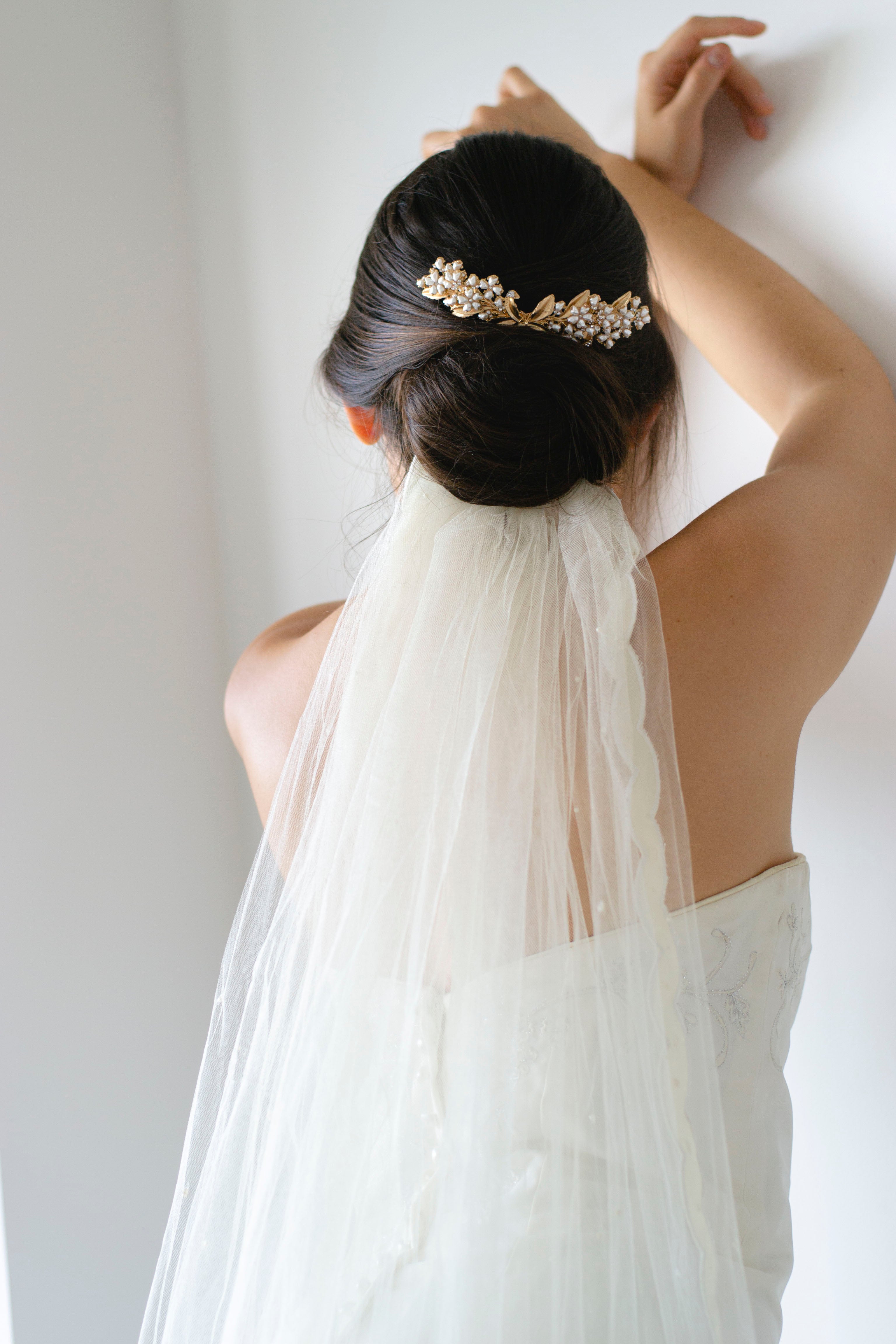 peigne de chignon mariage en or formant un bouquet de fleurs blanches