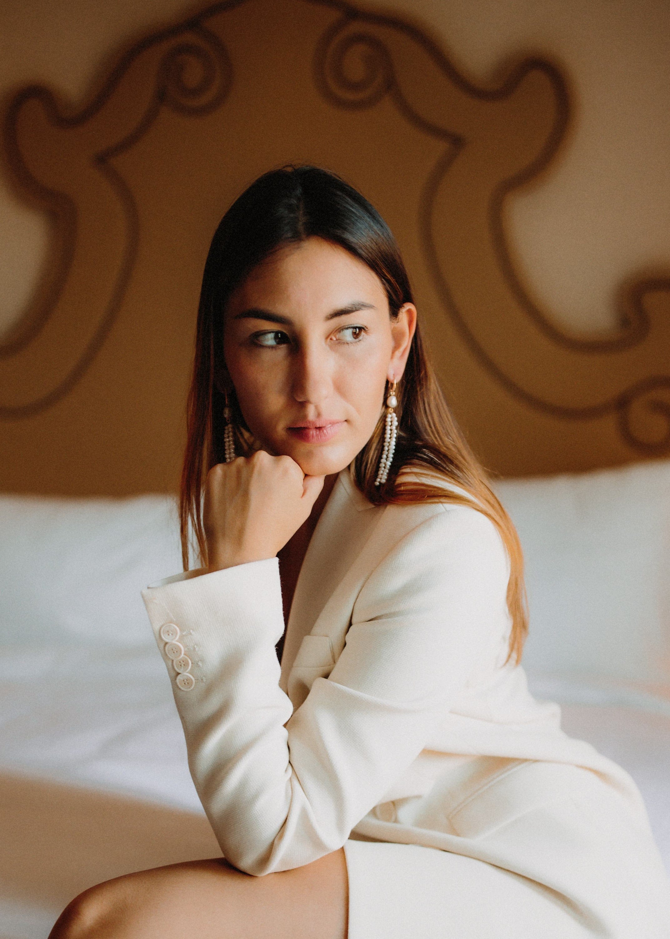 Femme en blazer blanc portant des Boucles d'Oreilles Pendantes perles