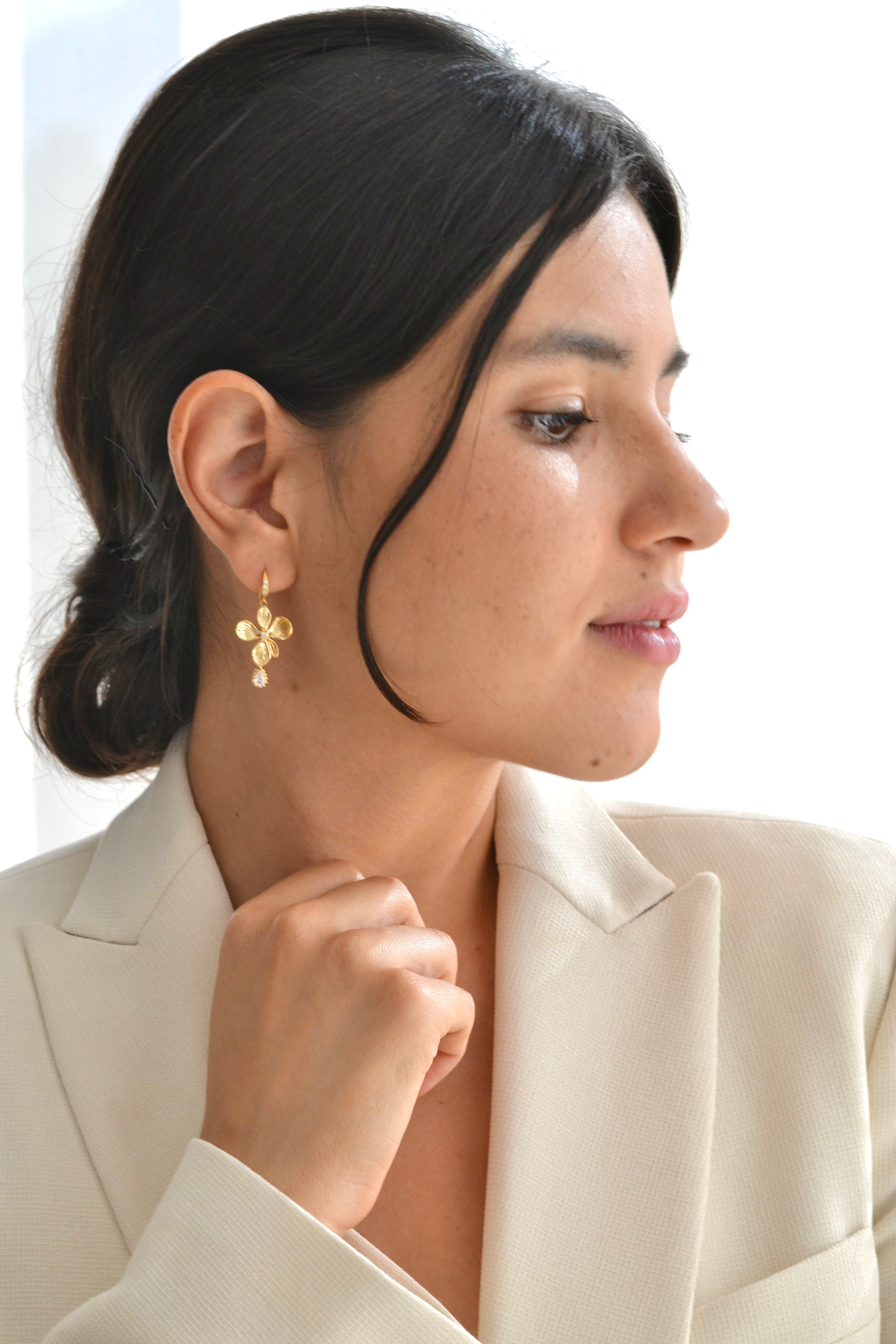 boucles d'oreilles mariage en or veille en forme de fleurs avec un cristal porté par une demoiselle d'honneur