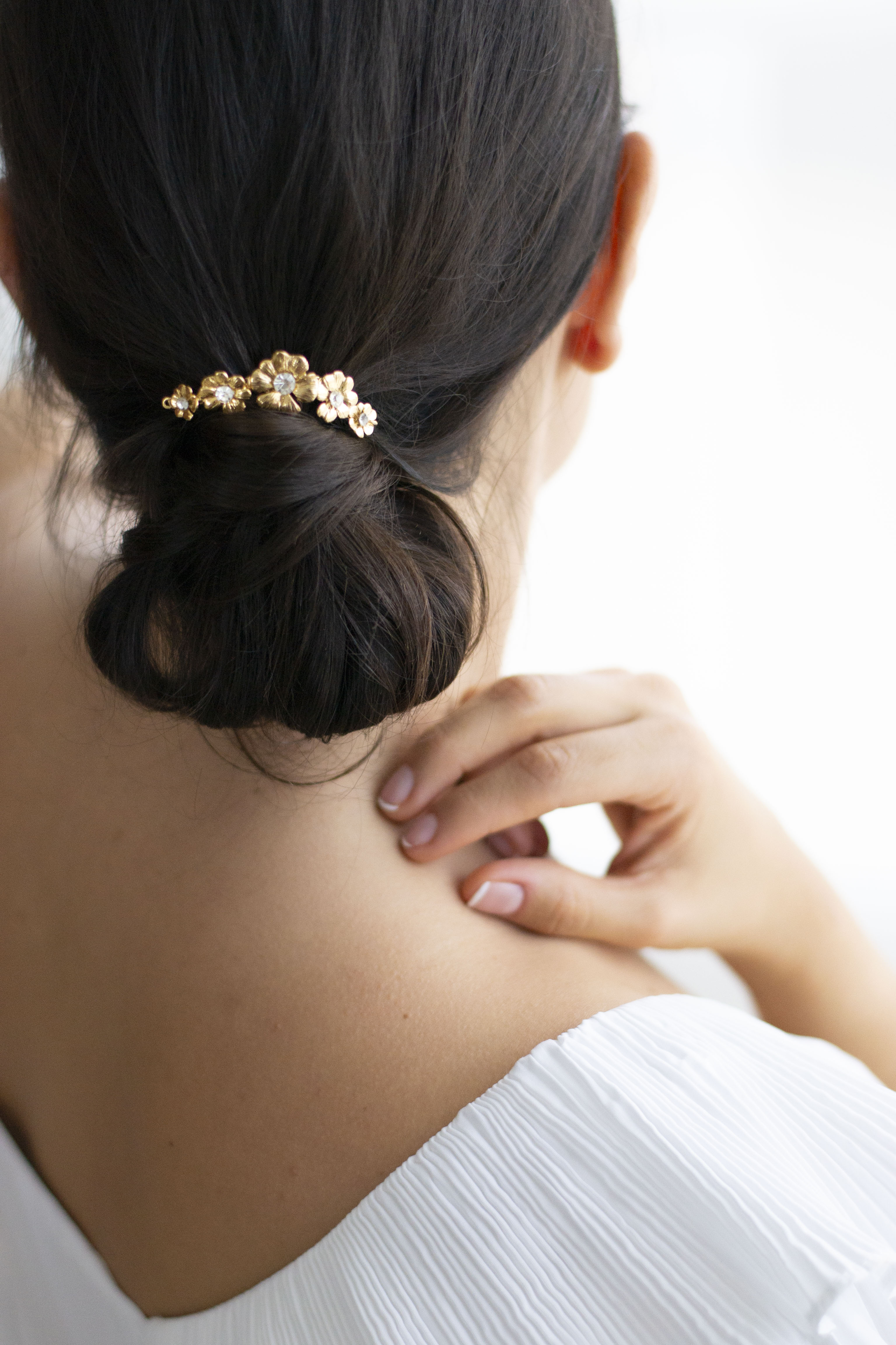 pic à chignon mariage ave 5 fleurs sur un chignon bas