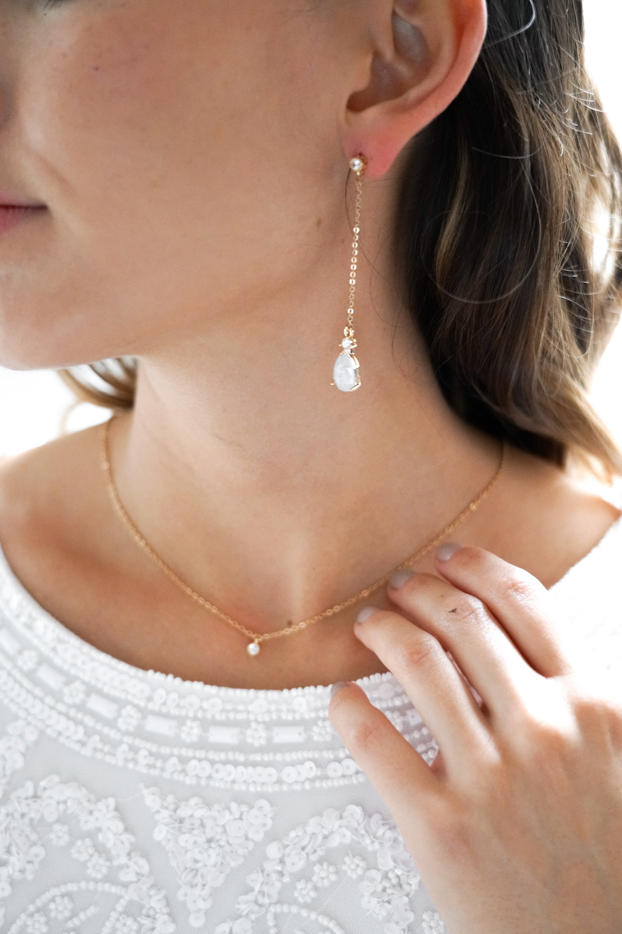 boucles d'oreilles pendantes mariage avec une chaine et un cristaux porté par une demoiselle d'honneur