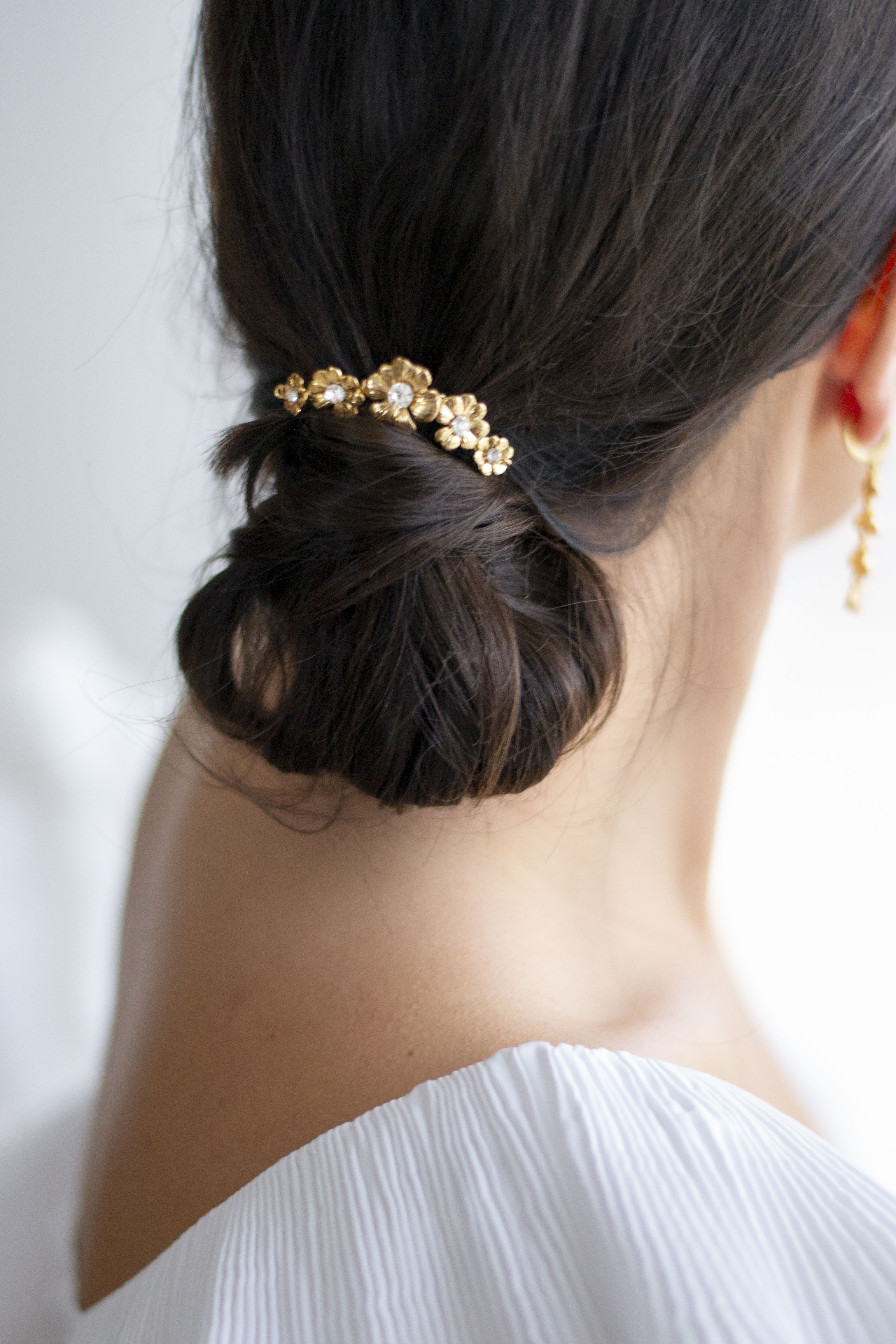pic à chignon mariage ave 5 fleurs sur un chignon bas
