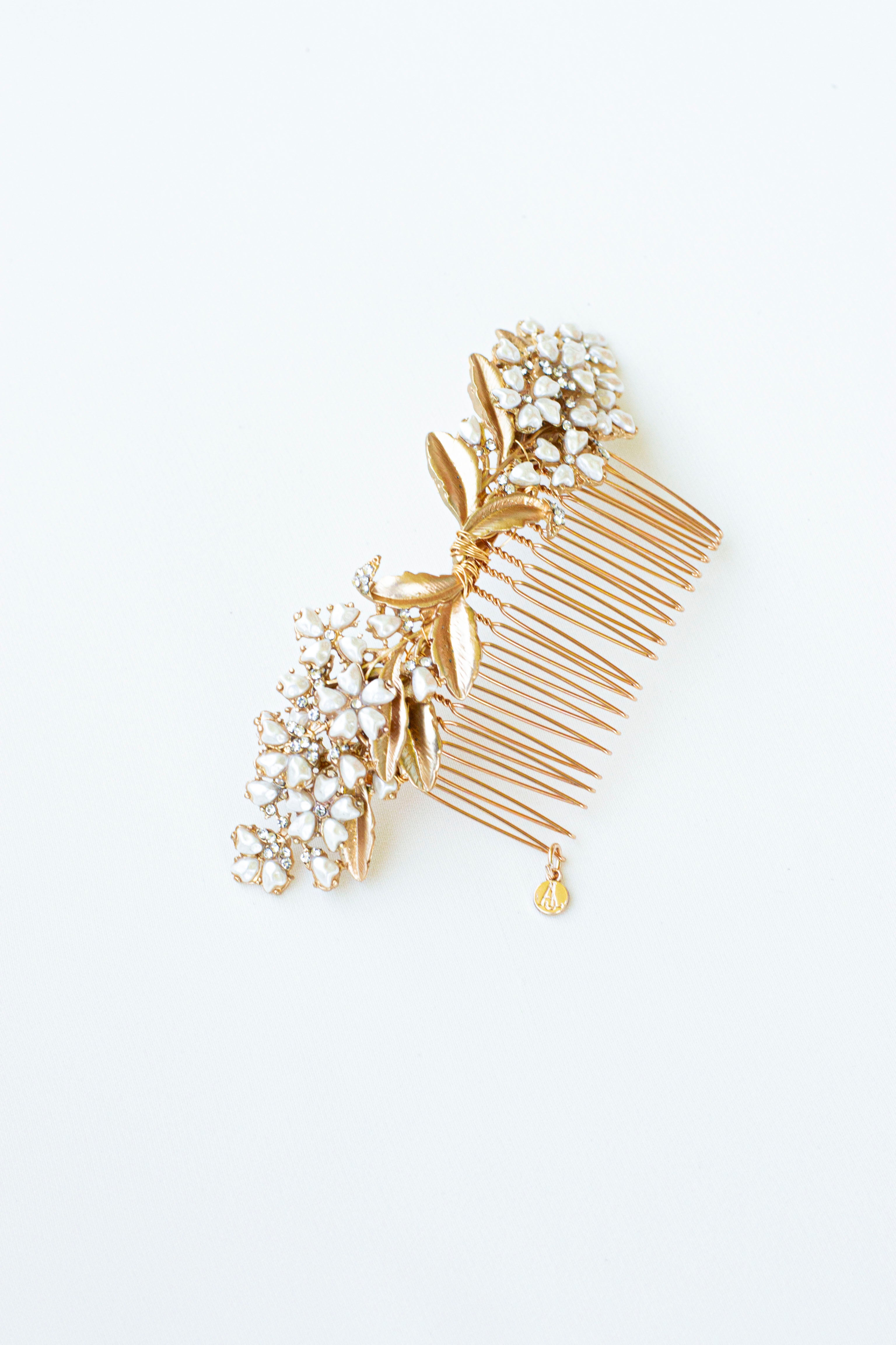 peigne de mariage en or pour les cheveux formant deux petits bouquets de fleurs blanche