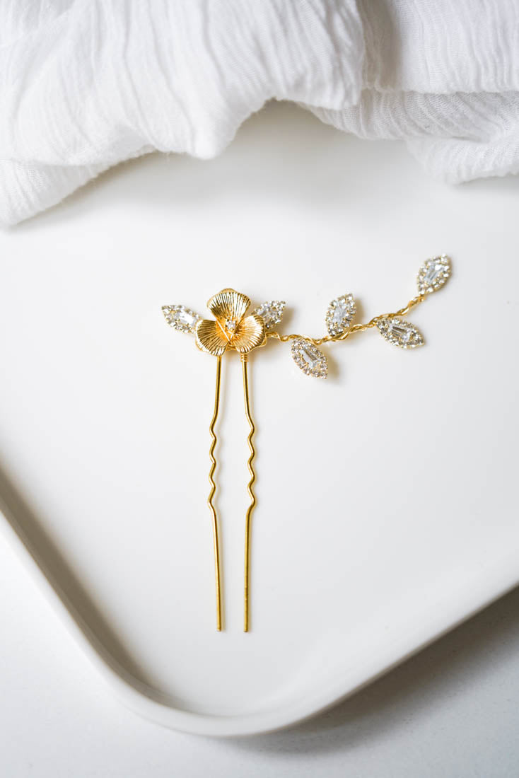 pic de cheveux mariage floral avec une fleur en centre ainsi qu'une branche de feuille en strass