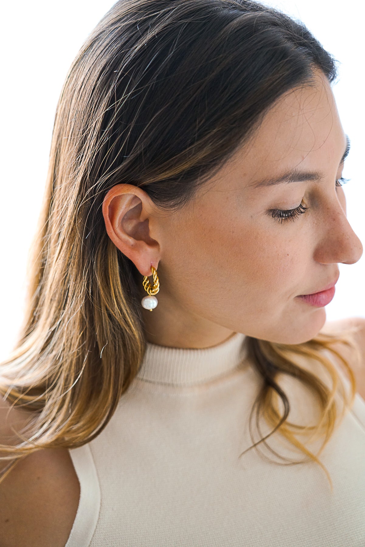 Femme portant Boucles d'oreilles créoles entrelacées dorée avec une perle