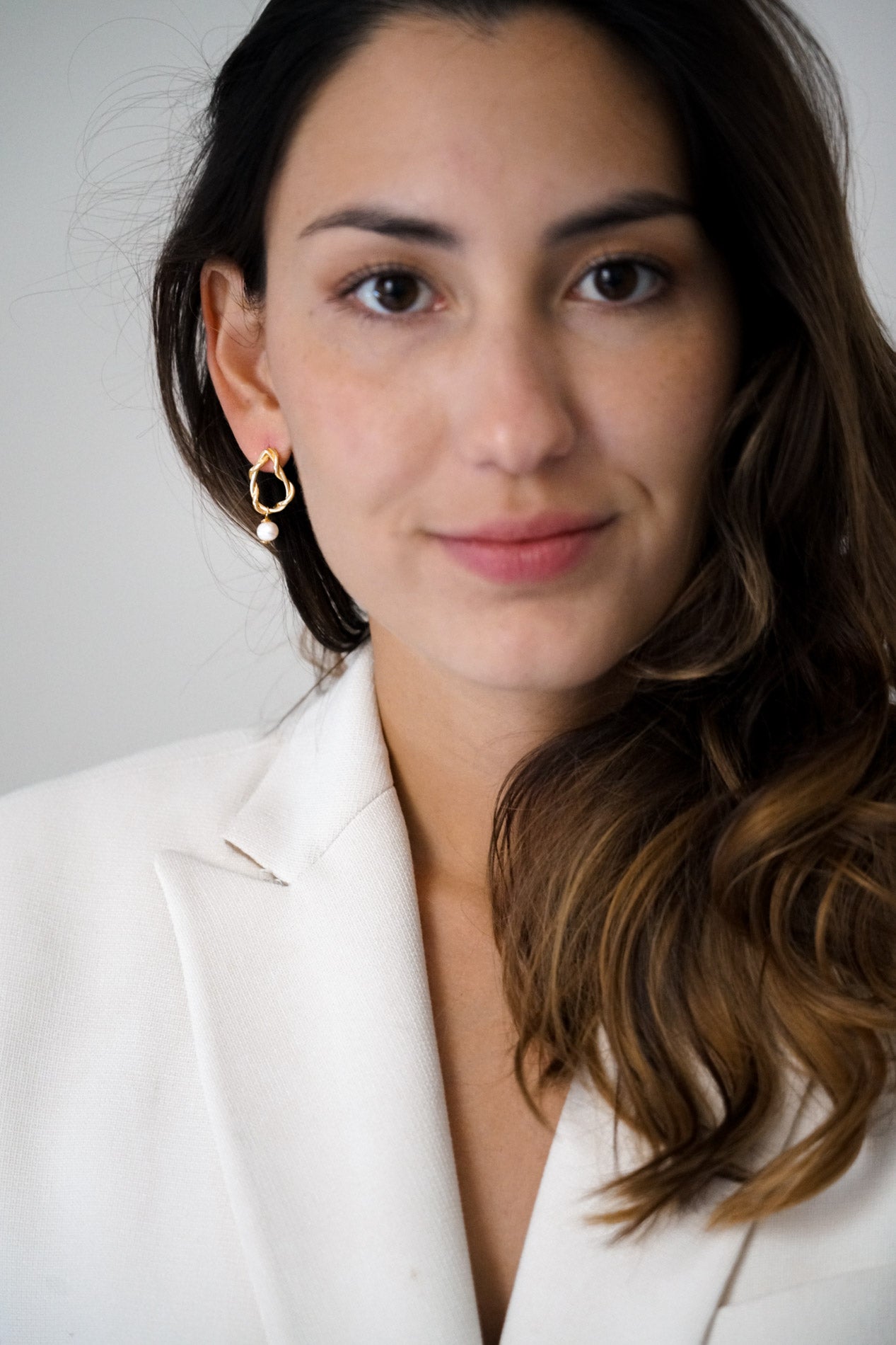 Mariée avec boucles d'oreilles à anneaux entremêlés et perle naturelle blanche