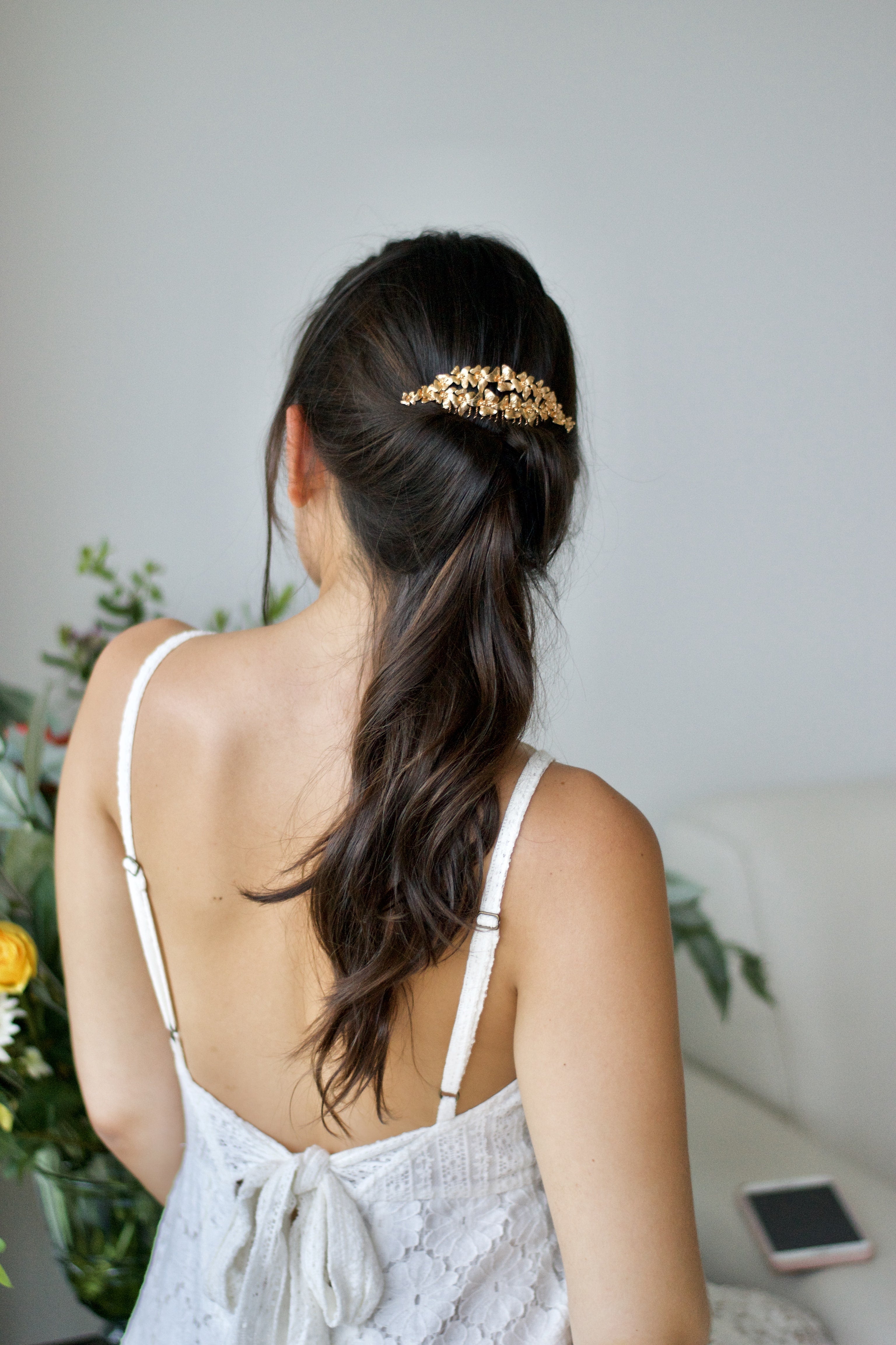 peigne de mariage floral bohème porté par la mariée avec un queue de cheval base