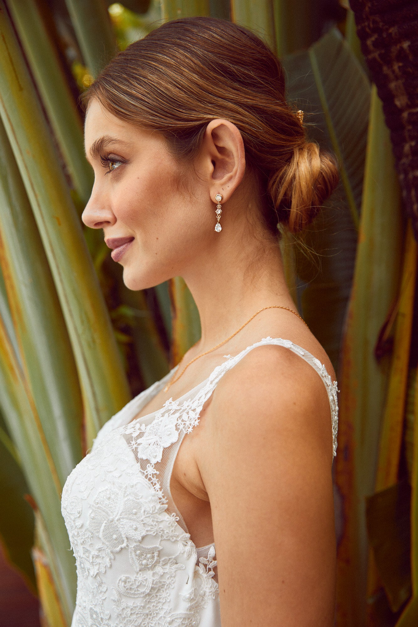 mariée portant des petites boucles d'oreilles et un chignon bohème