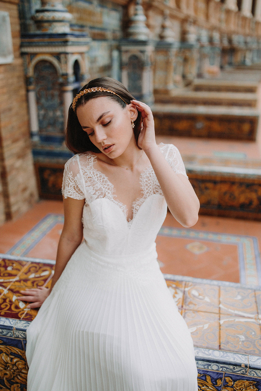 Mariée bohème et romantique avec une couronne à fleurs dorées et boucles d'oreilles pendantes dorées à cristaux