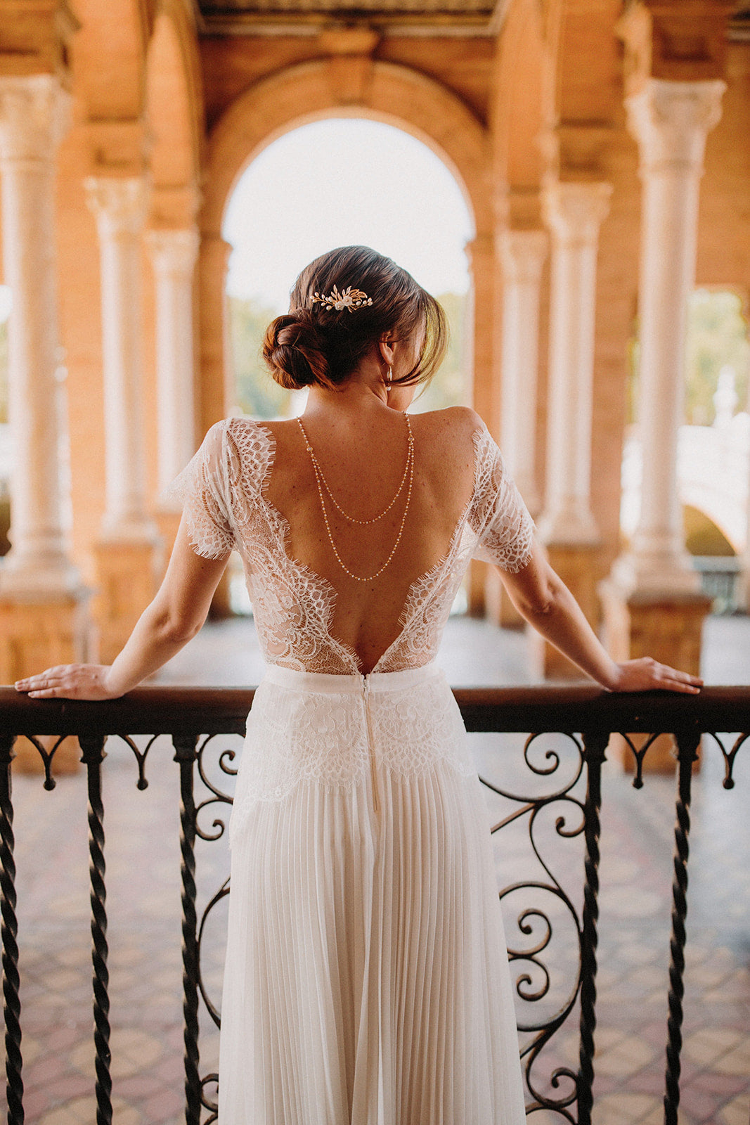 mariée à Séville portant une robe de mariée blanche à dentelle avec un dos nu et un collier de dos