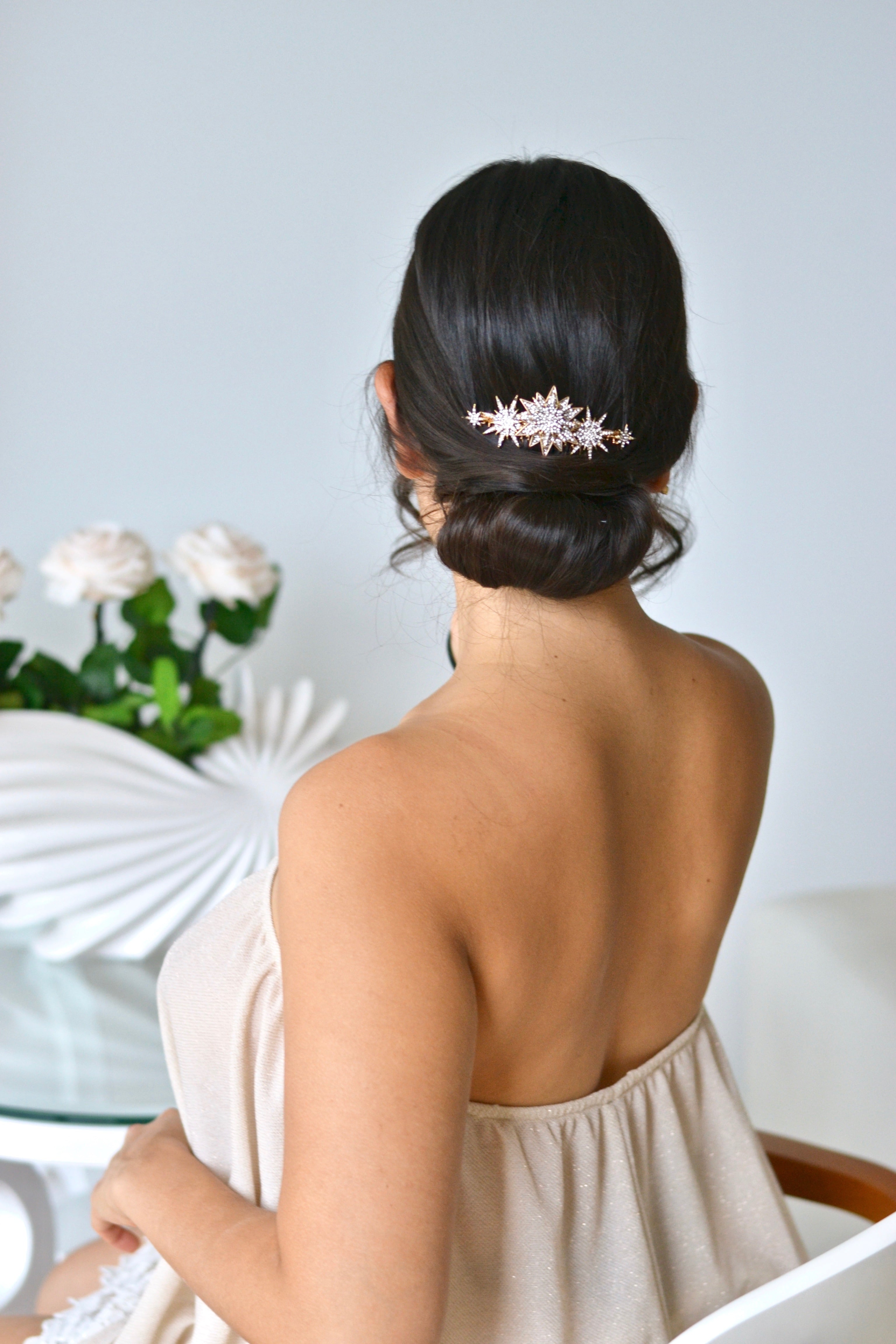 peigne céleste avec des étoiles de différentes tailles sur un coupe de mariage en chignon bas