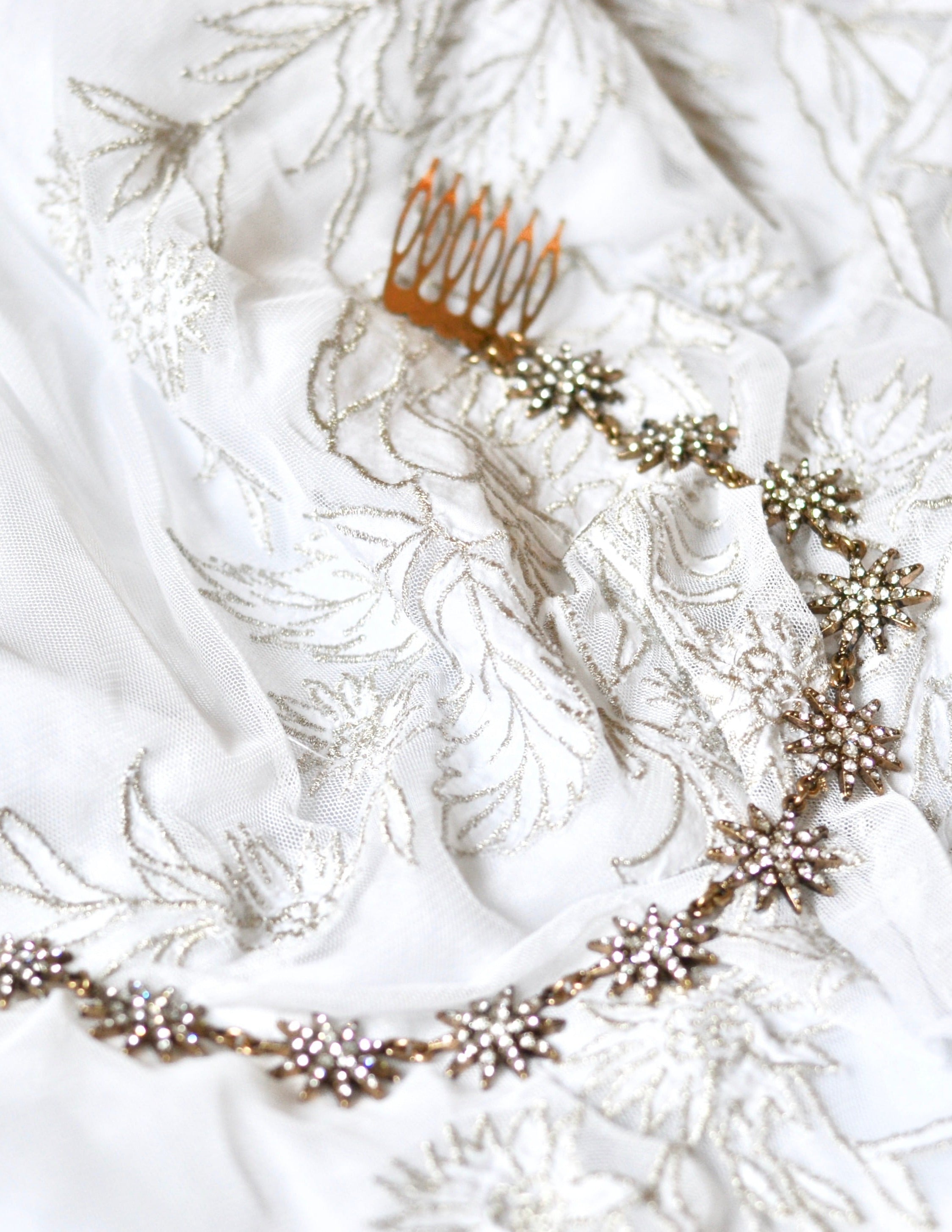 vigne de cheveux en or vieilli pour mariage avec des strass posé sur un linge blanc