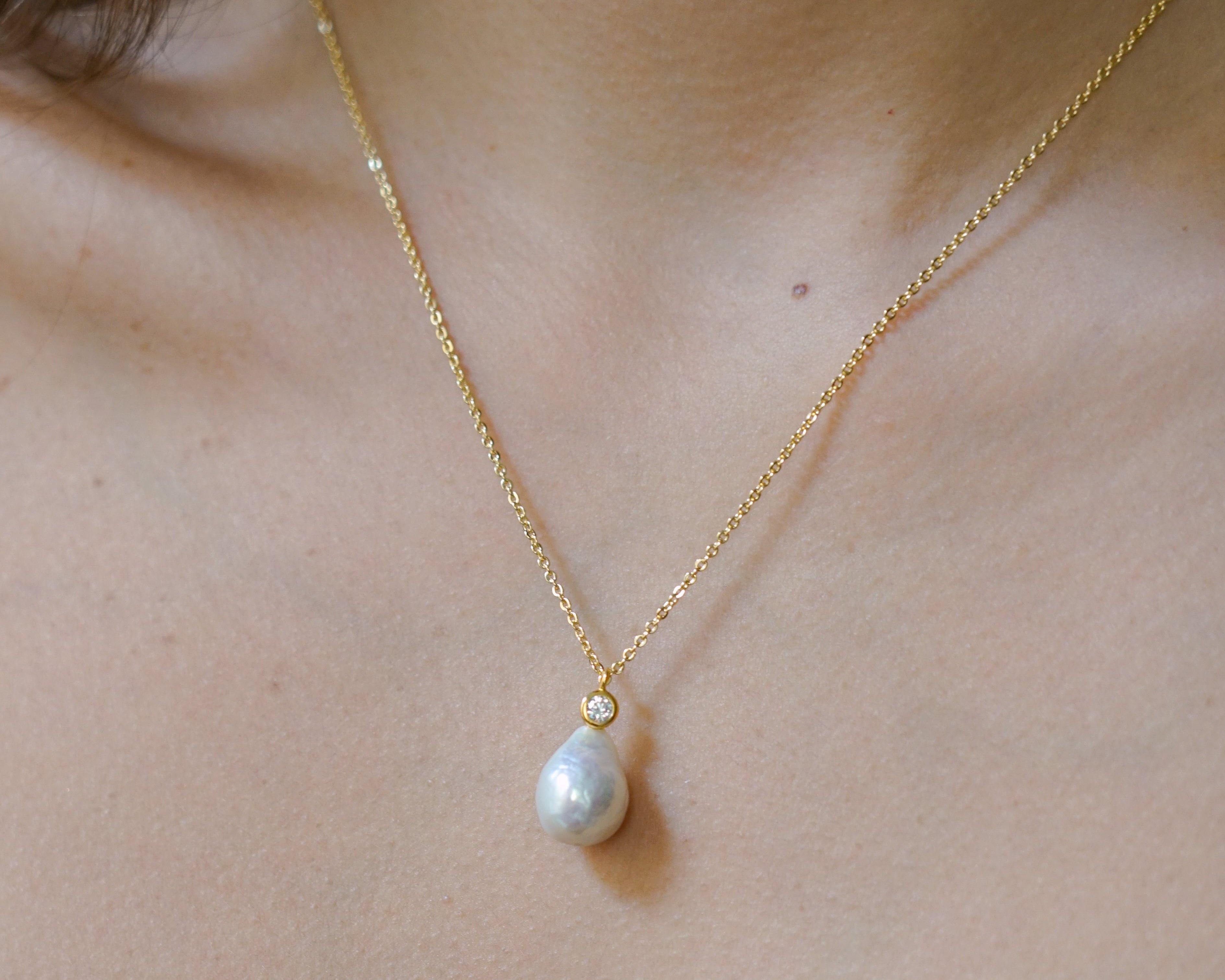 Collier long en or avec perle baroque porté pour un mariage