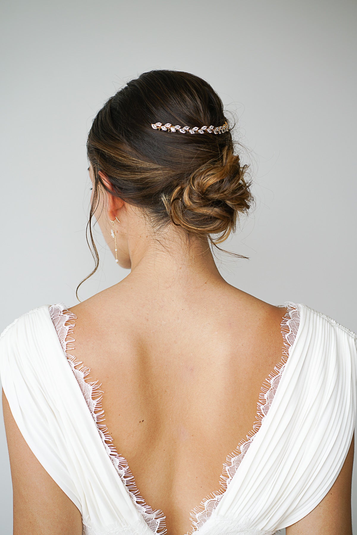 Mariée portant une vigne à cheveux dorée à cristaux