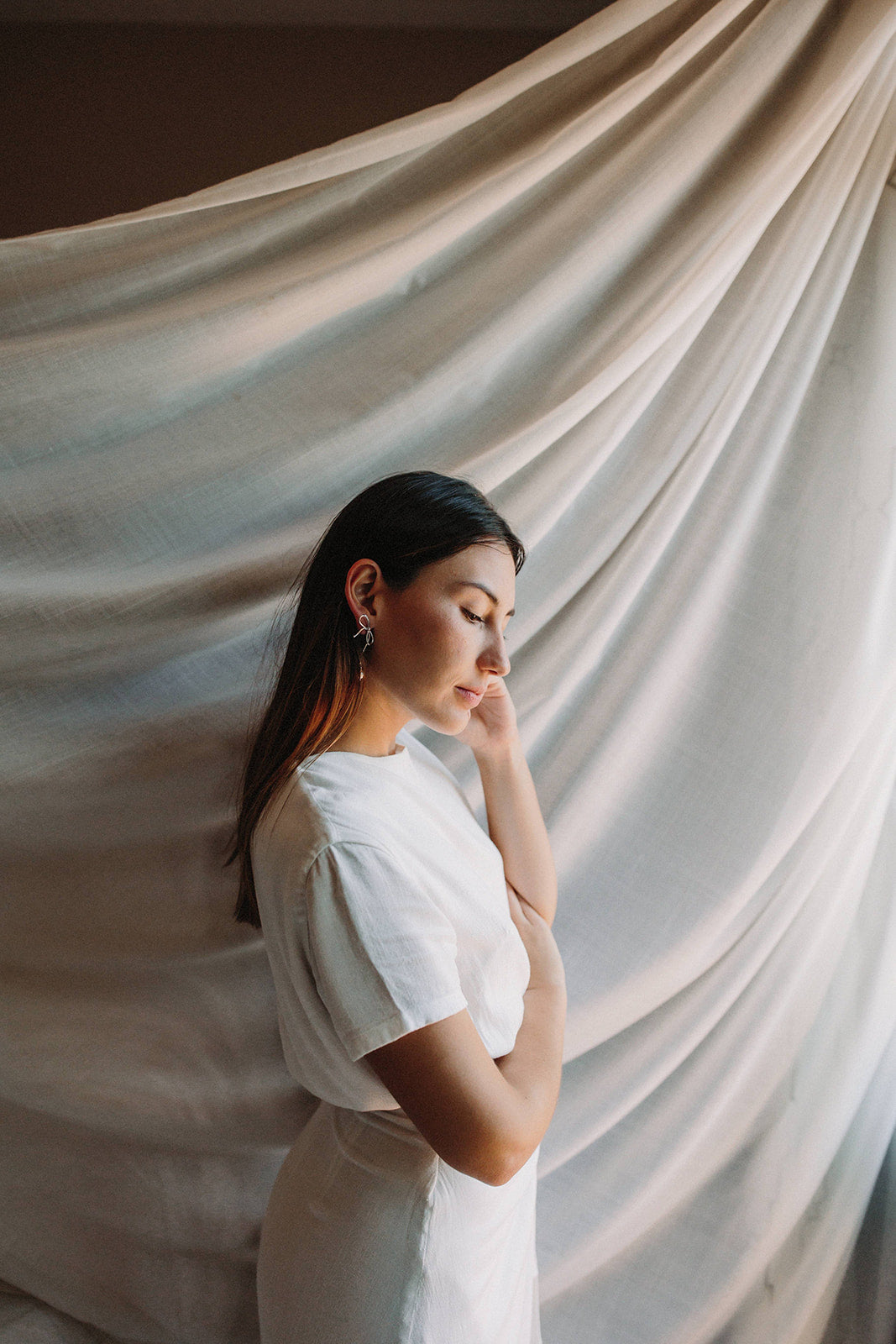 boucles d'oreilles mariage en argent en forme de noeud avec une perle porté par une demoiselle d'honneur