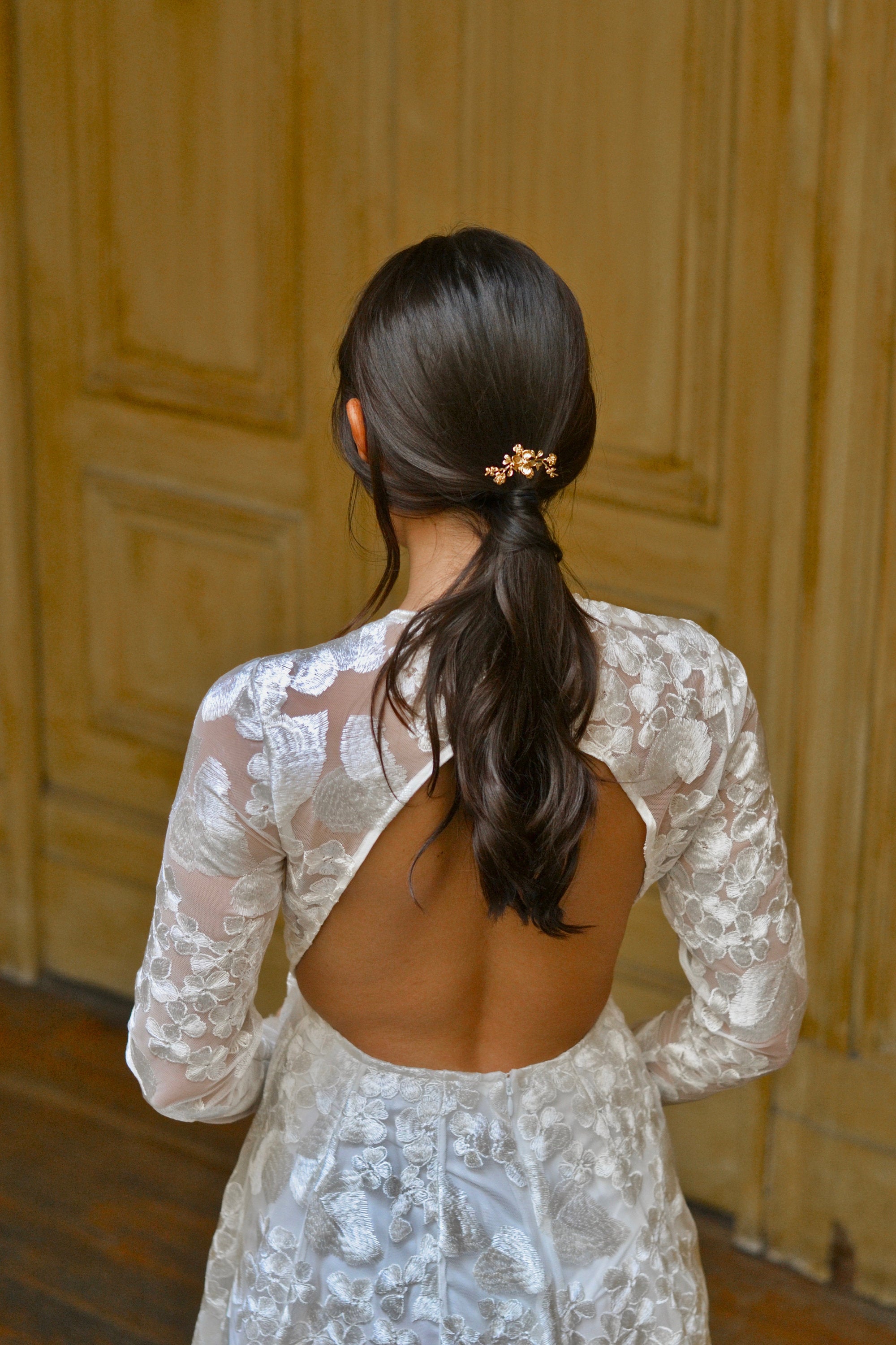 Mariée avec queue-de-cheval et petit pic à cheveux doré à fleurs