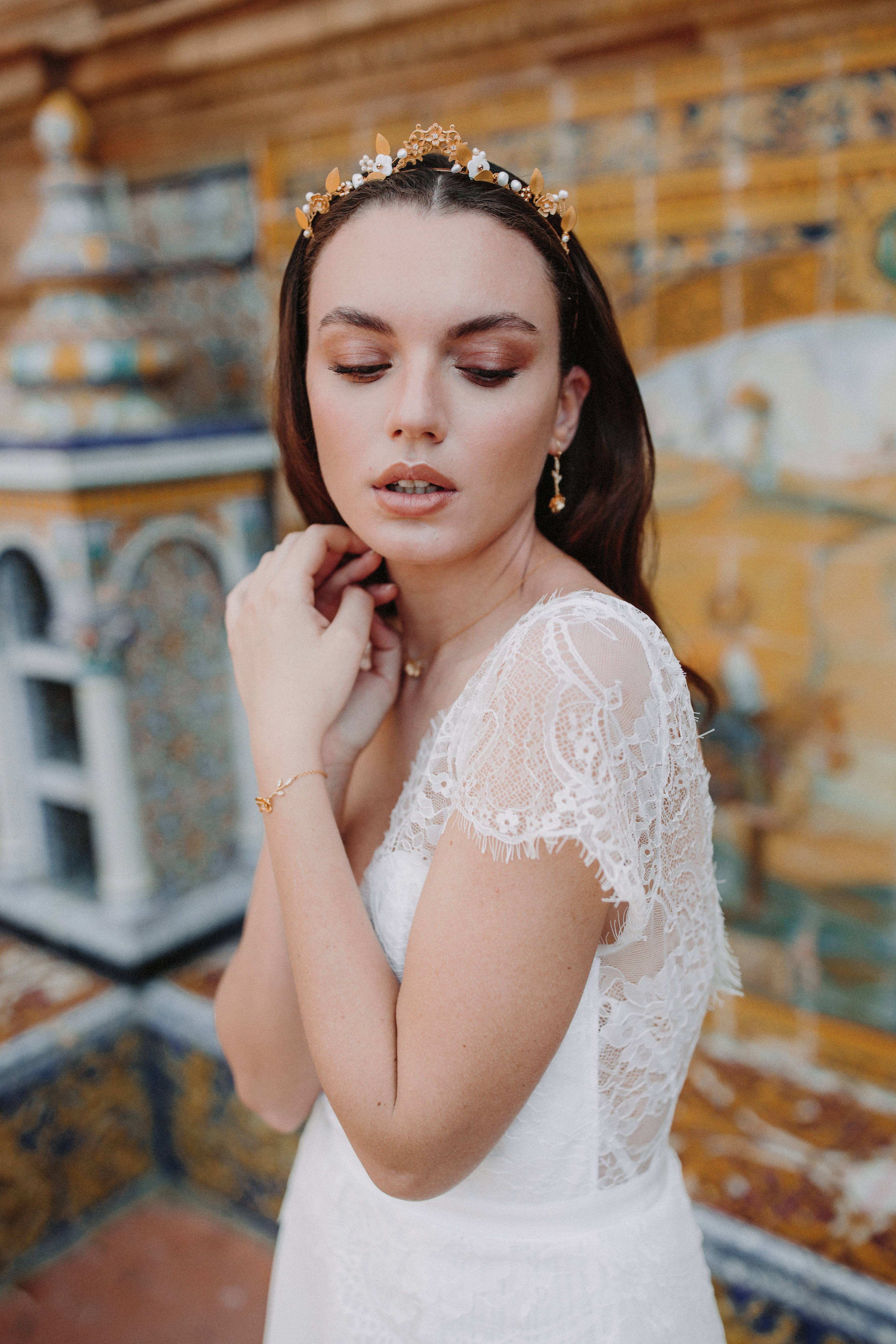 mariée portant un serre tête de mariage avec des fleurs et la parure de bijoux assortie