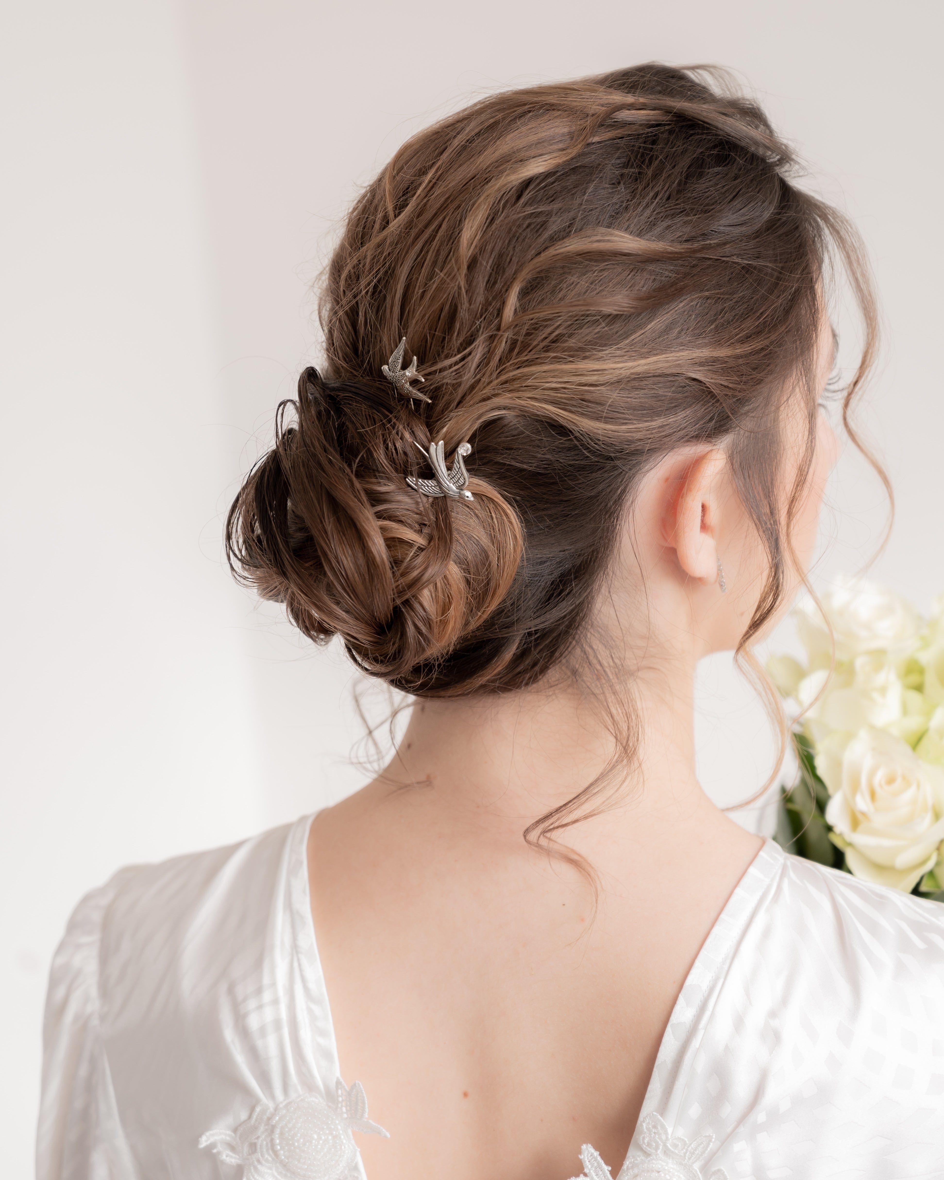 Mariée portant deux pics à cheveux argent avec des oiseaux, hirondelles signe de liberté