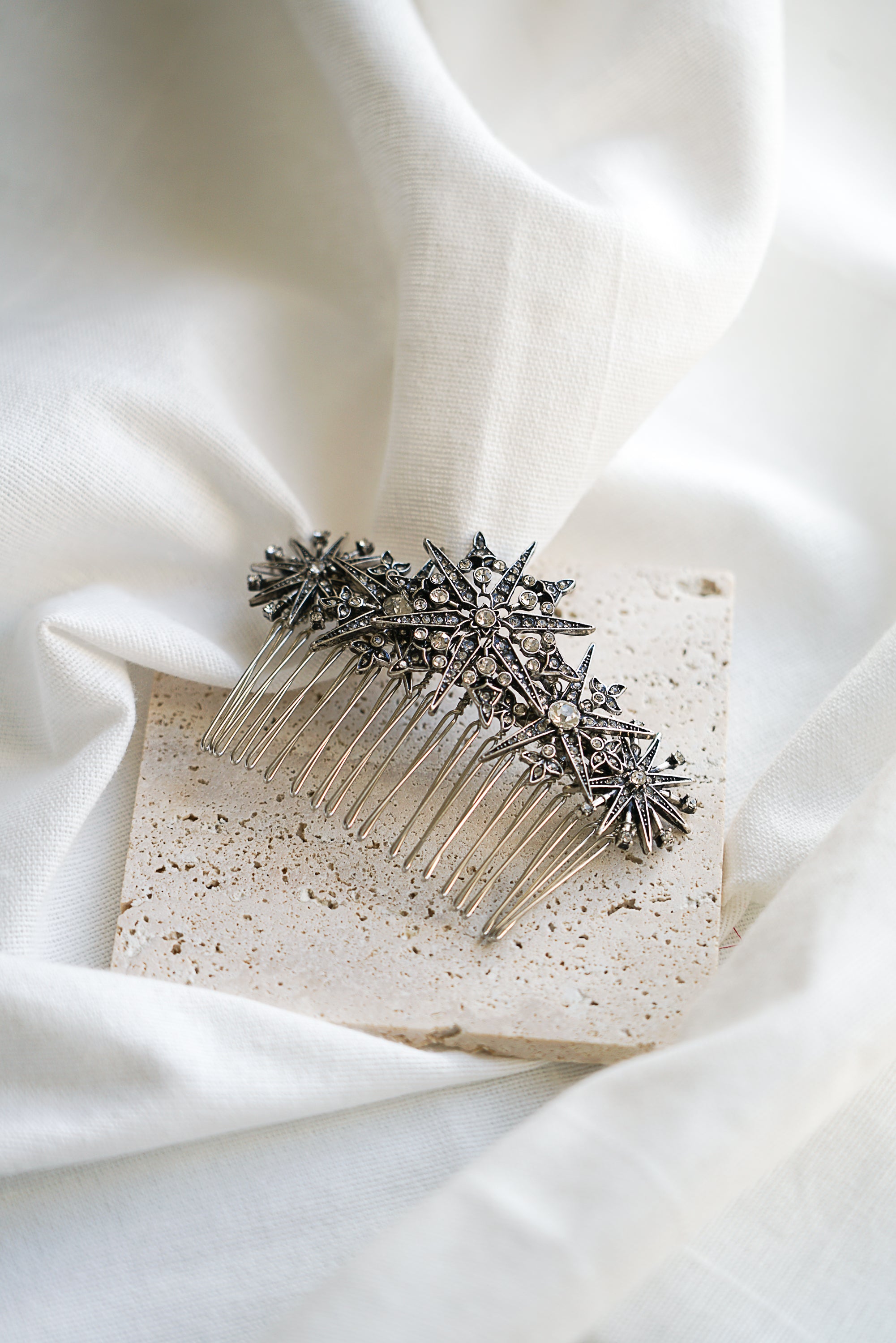 peigne de mariage céleste fait main avec 3 styles d'étoiles différentes sur une petite plaque de marbre beige