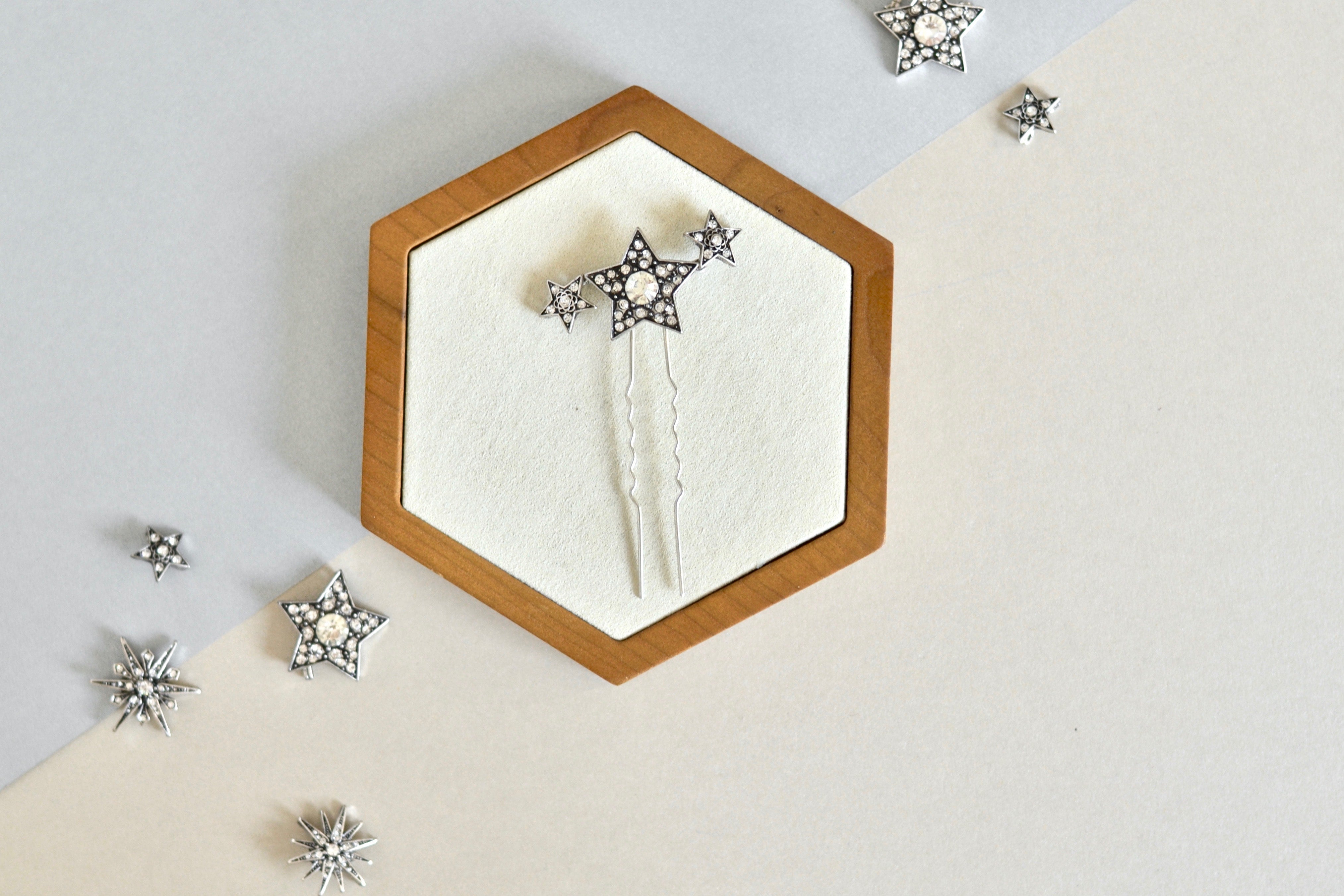 pic à cheveux céleste composé d'une grande étoile et de deux petites sur un socle blanc et en bois