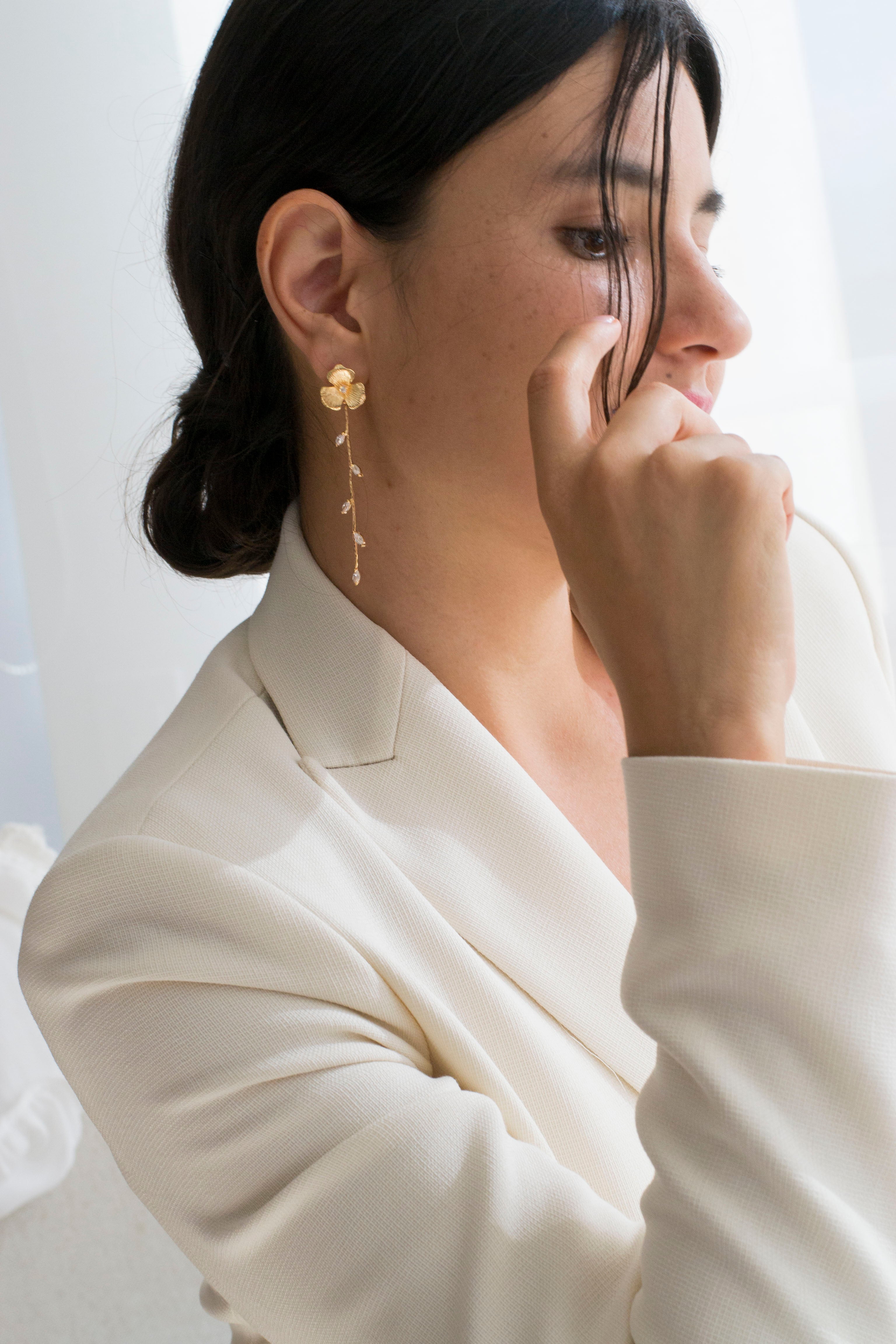 Boucles d'oreilles pendantes fait à la main avec une fleur pour le centre de la boucle et une blanche de feuilles en pendentif porté par une invitée du mariage