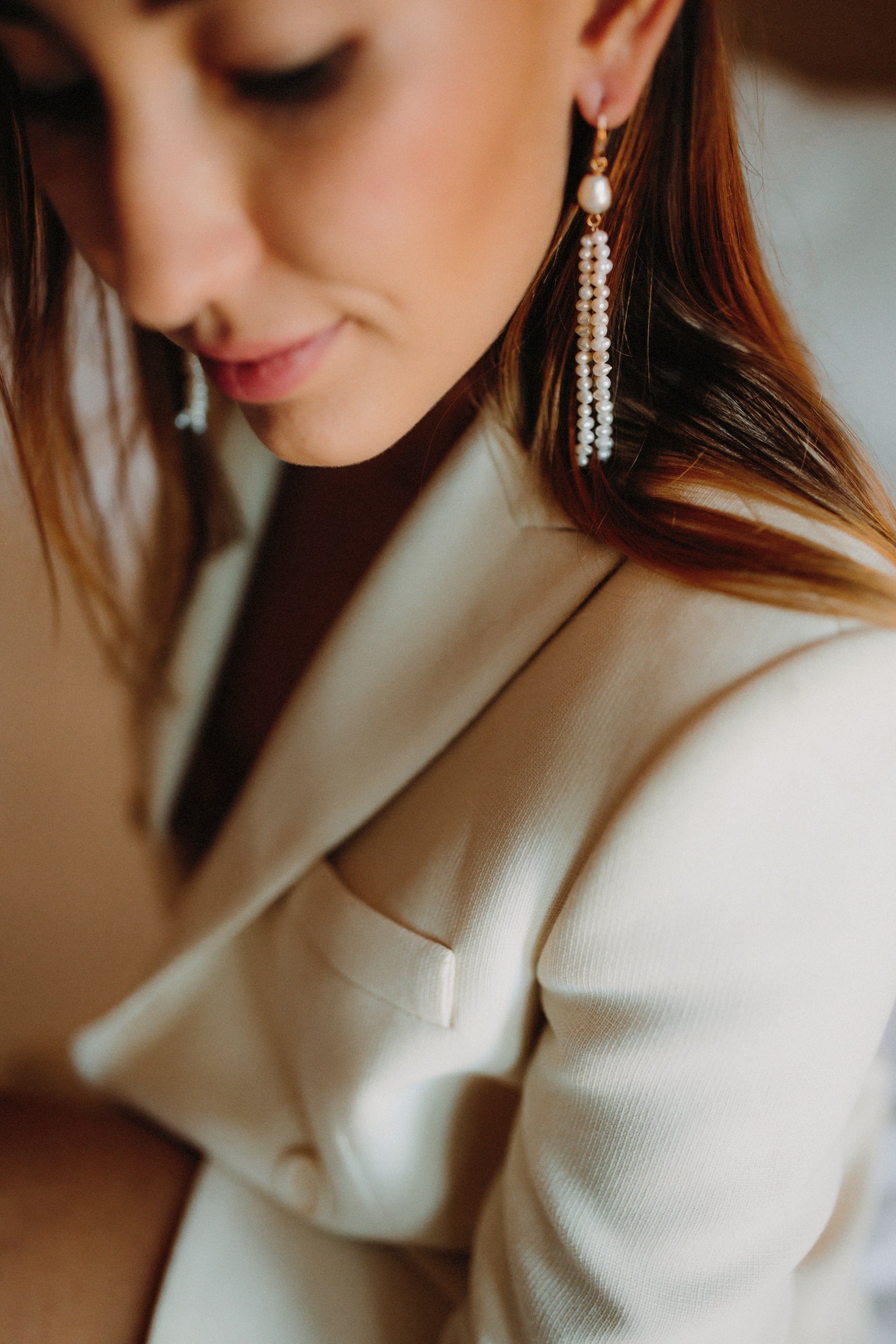 Mariée portant des boucles d'oreilles pendantes en perles naturelles blanches
