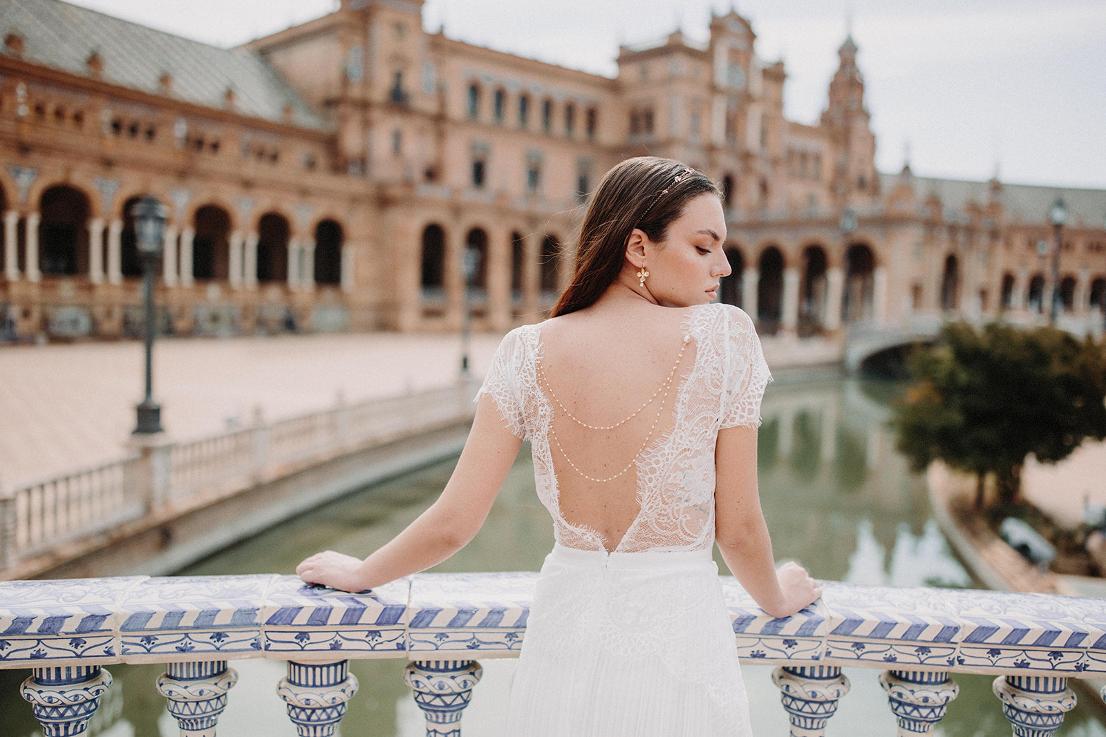 Mariée portant un bijou de robe à perles, des boucles d'oreilles à fleurs en or et une chaîne de cheveux dorée