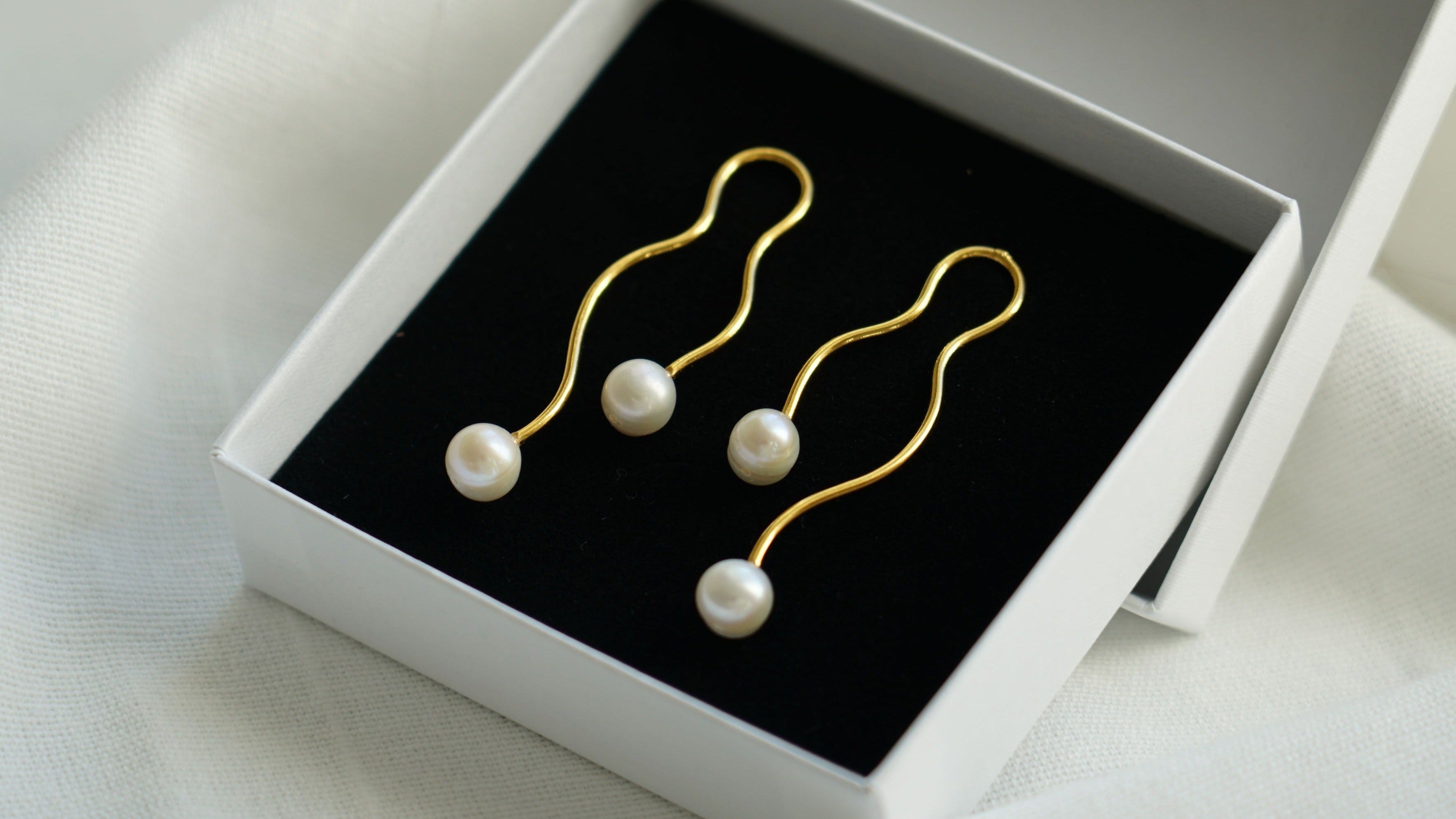 Boucles d'oreilles dorées modernes avec perles naturelles blanches