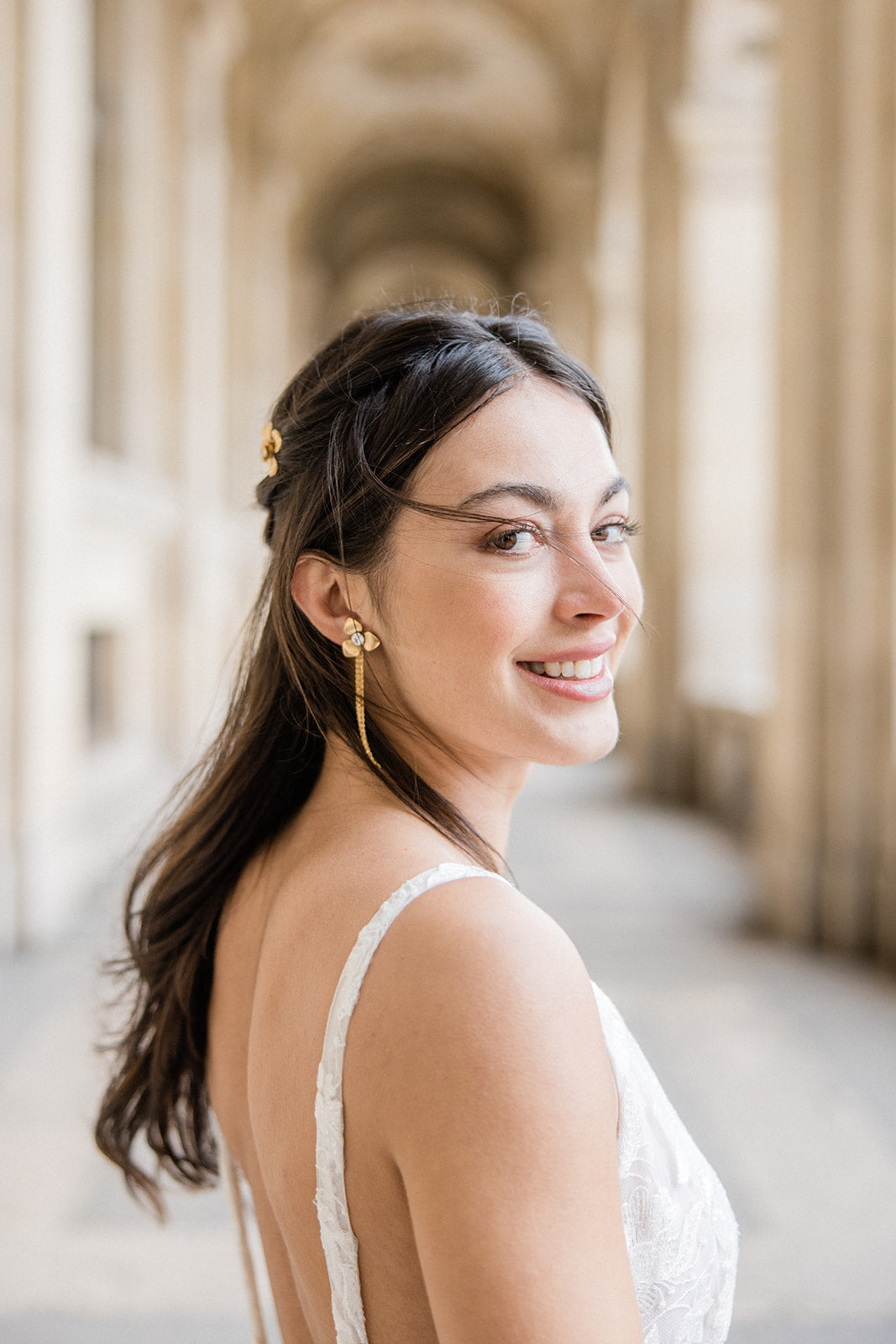 Mariée portant des boucles d'oreilles à fleurs dorées