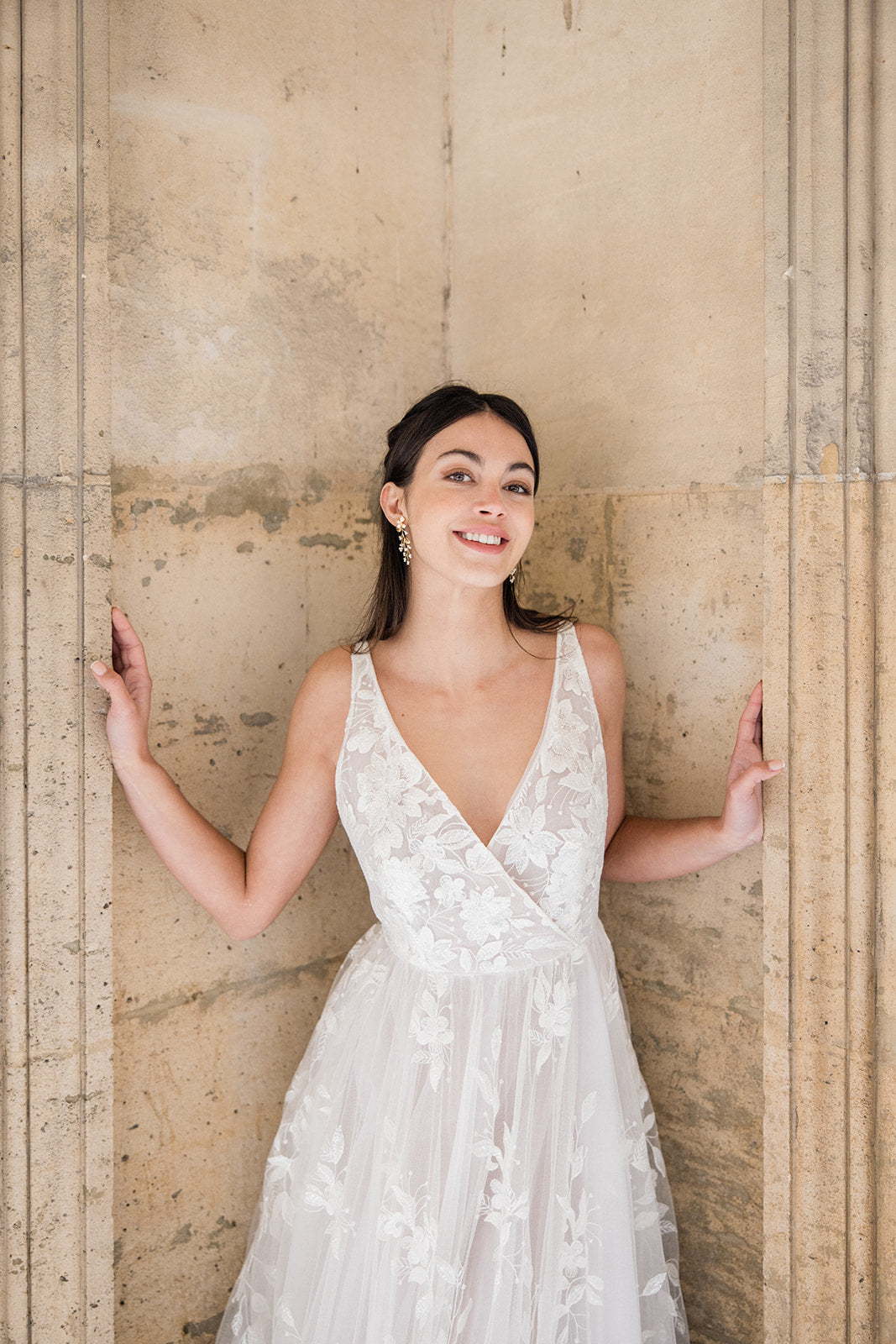 Mariée portant des boucles d'oreilles pendantes de fleurs et feuilles dorés avec des petites perles rocaillle