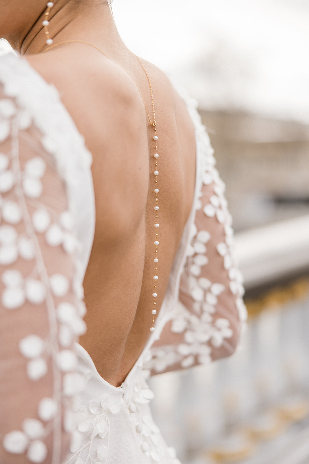 mariée de dos portant un collier de dos sur son décolleté de robe