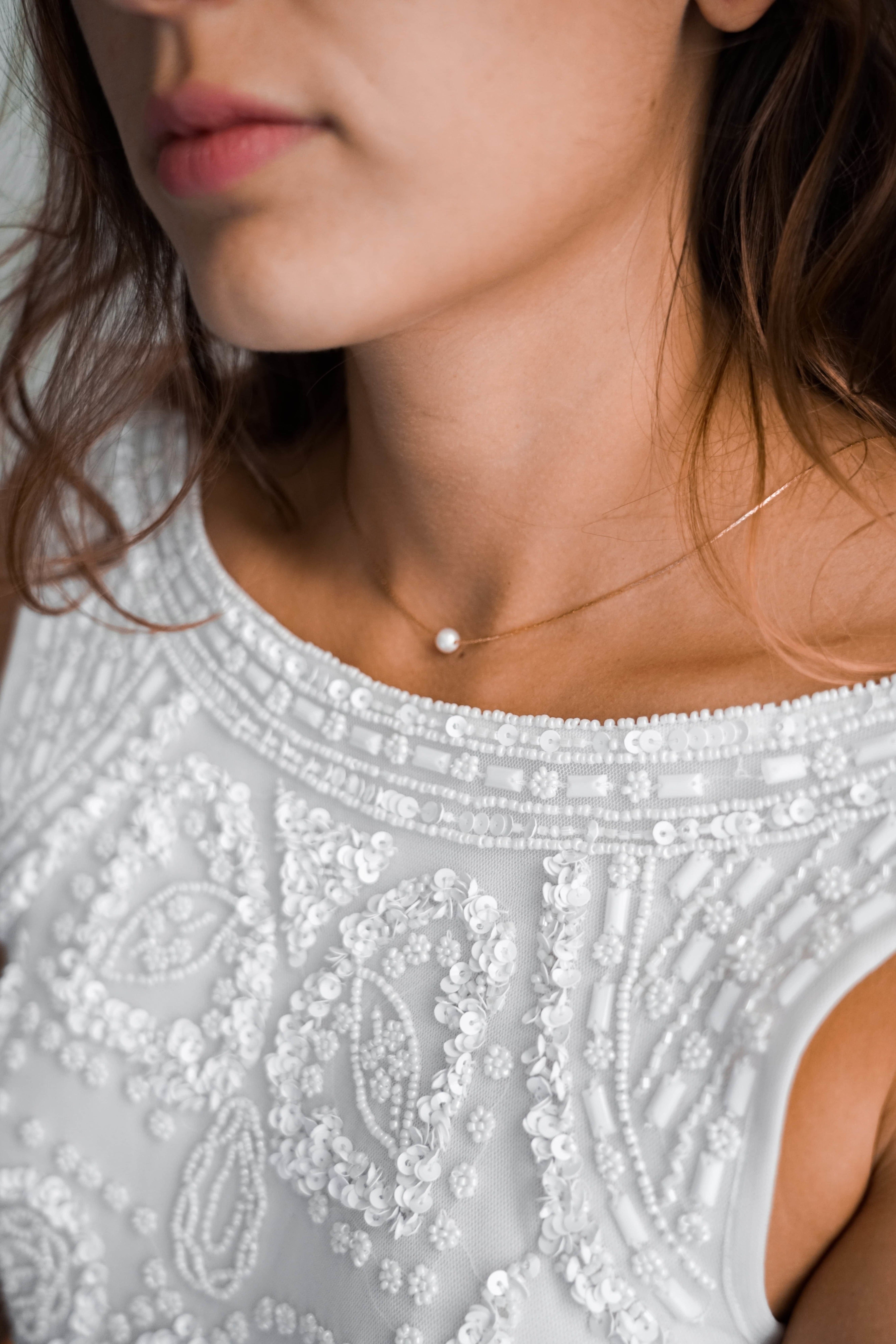 mariée portant un collier de mariage avec un robe sans décolleté et avec des sequins cousus