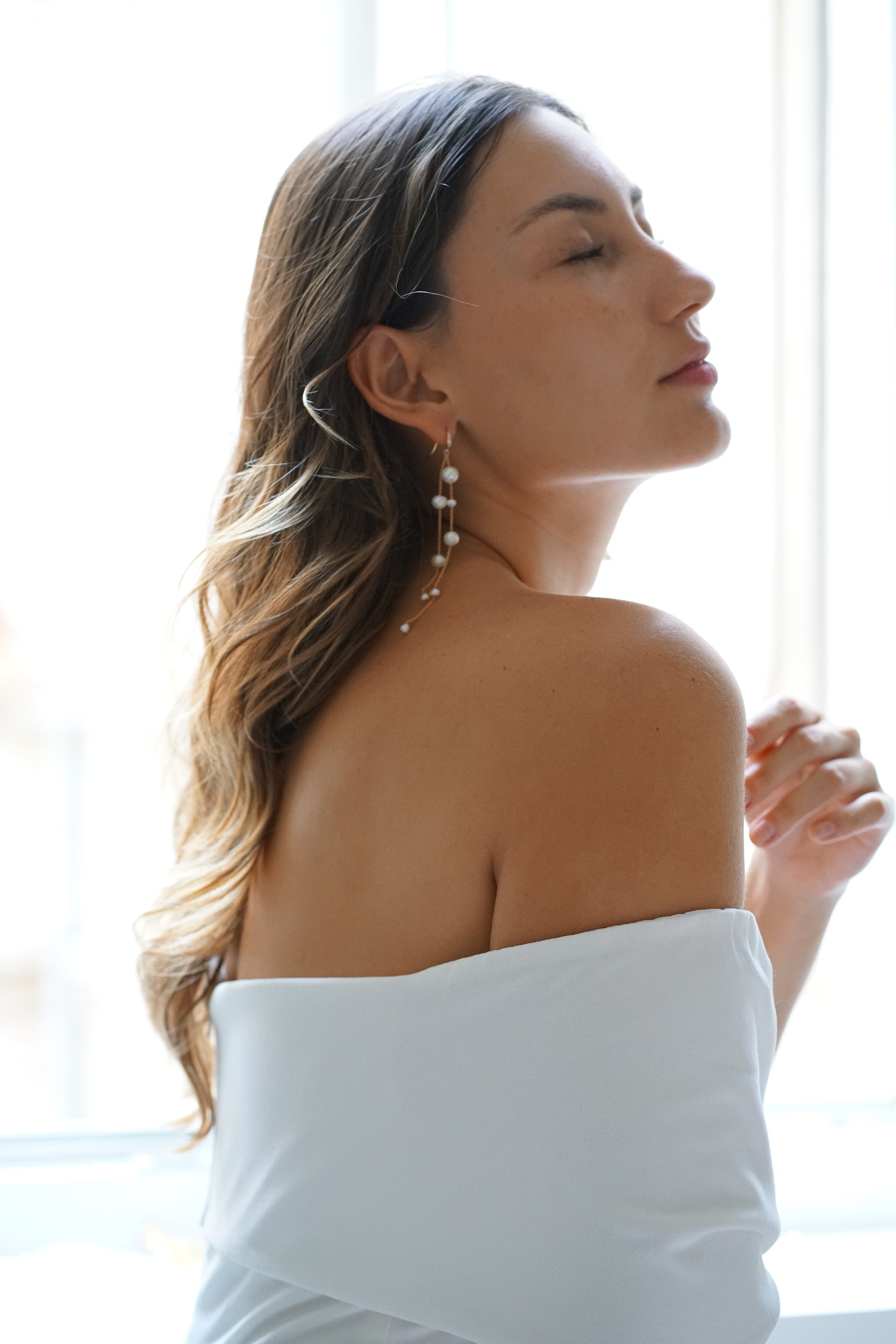 Mariée portant des boucles d'oreilles pendantes longues à perles