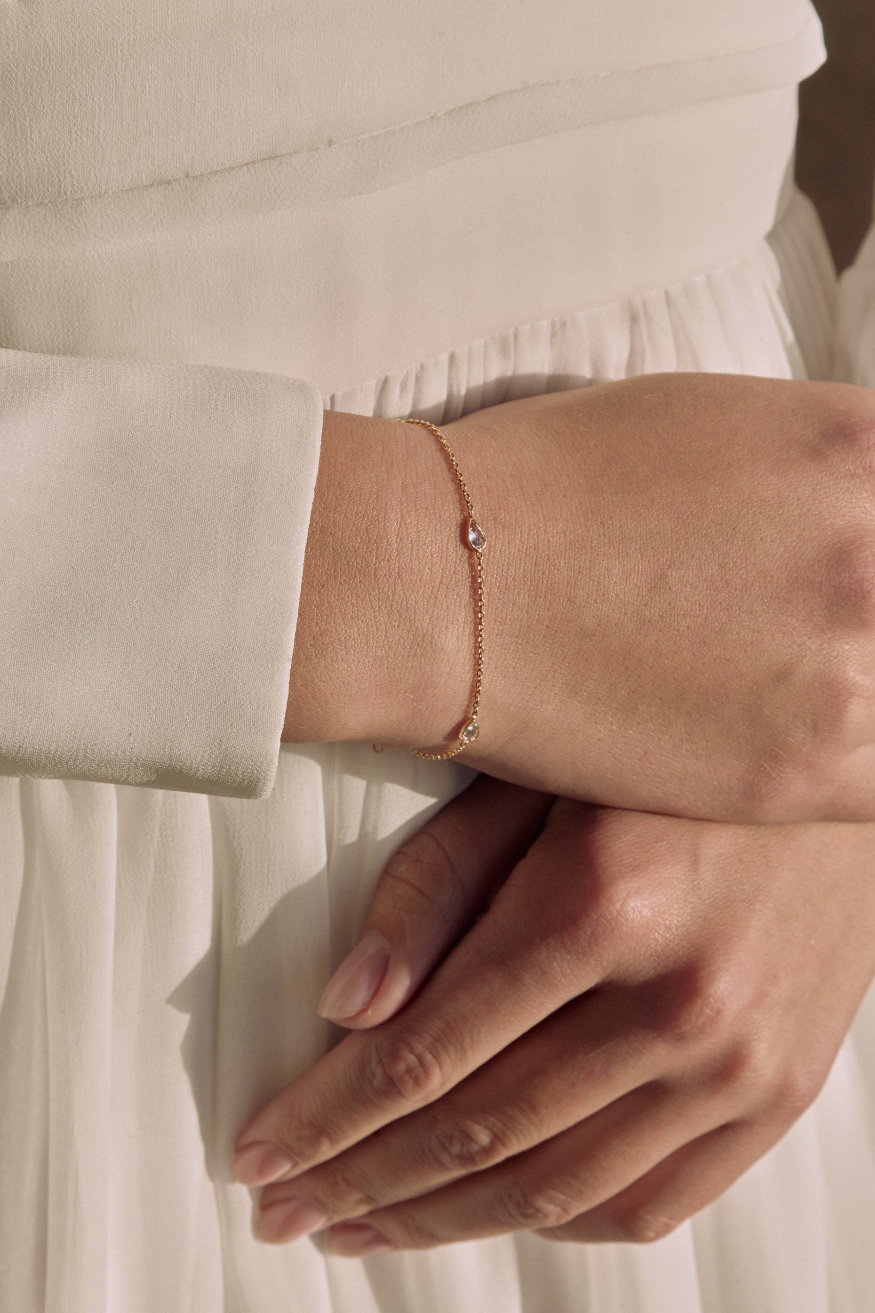 Photo des mains d'une femme montrant un bracelet raffinée avec cristaux délicats