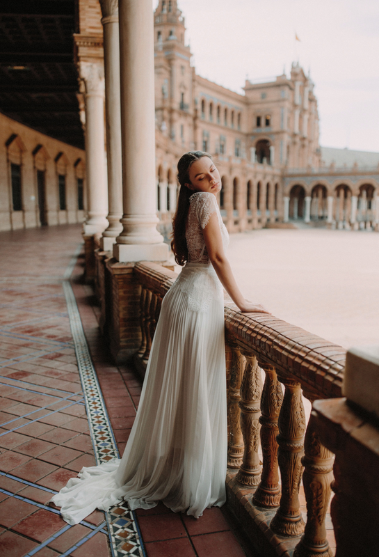 mariée à Séville portant une robe blanche à dentelle avec des bijoux d'Atelier Lilac