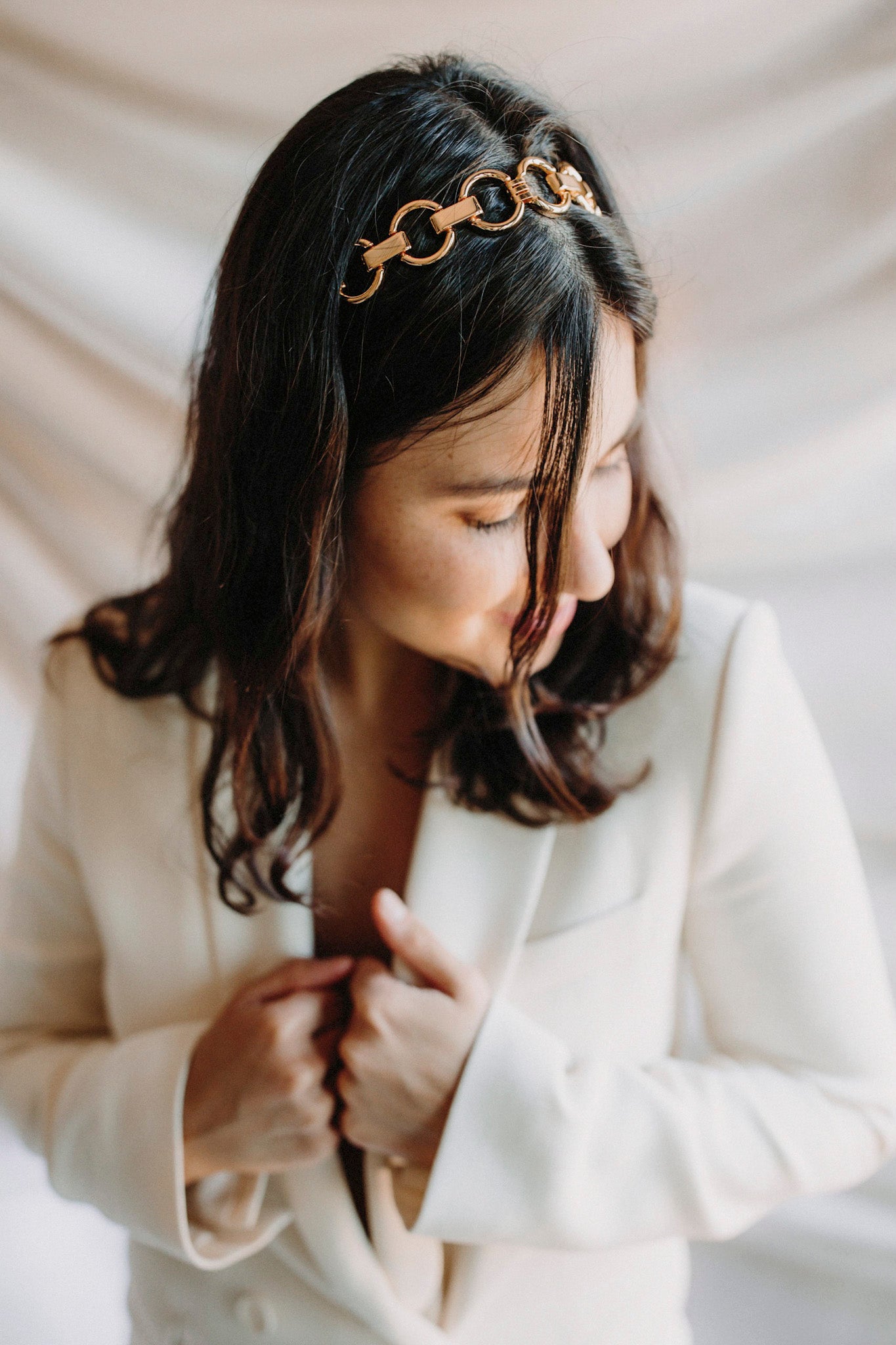 Headband en chaines à grands maillots ronds couleur or porté par une mariée en blazer blanc