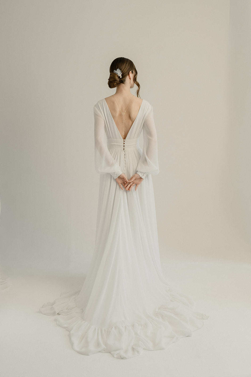 femme portant une robe de mariage avec un décolleté de dos et un chignon avec un peigne