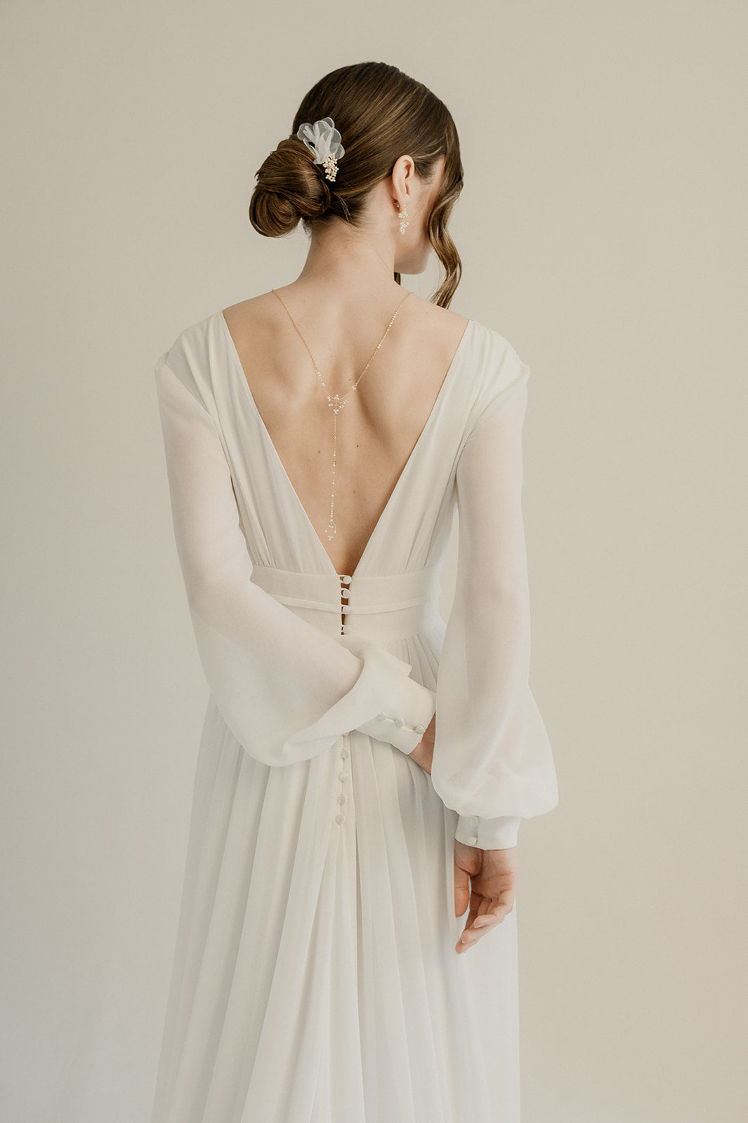 femme portant une robe de mariage avec un décolleté de dos et un chignon avec un peigne