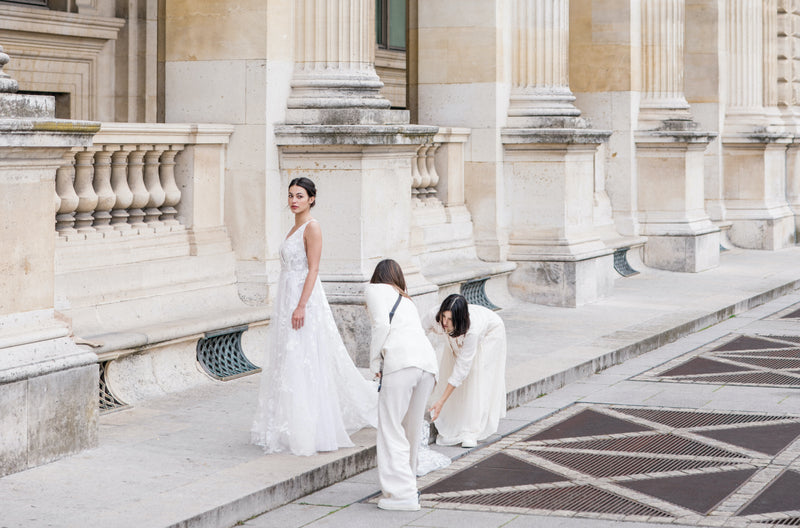 Mariée sur la place du Louvre à Paris entrain d'être préparé pour le shooting par les deux créatrice lors du backstage du shooting de la collection 2023
