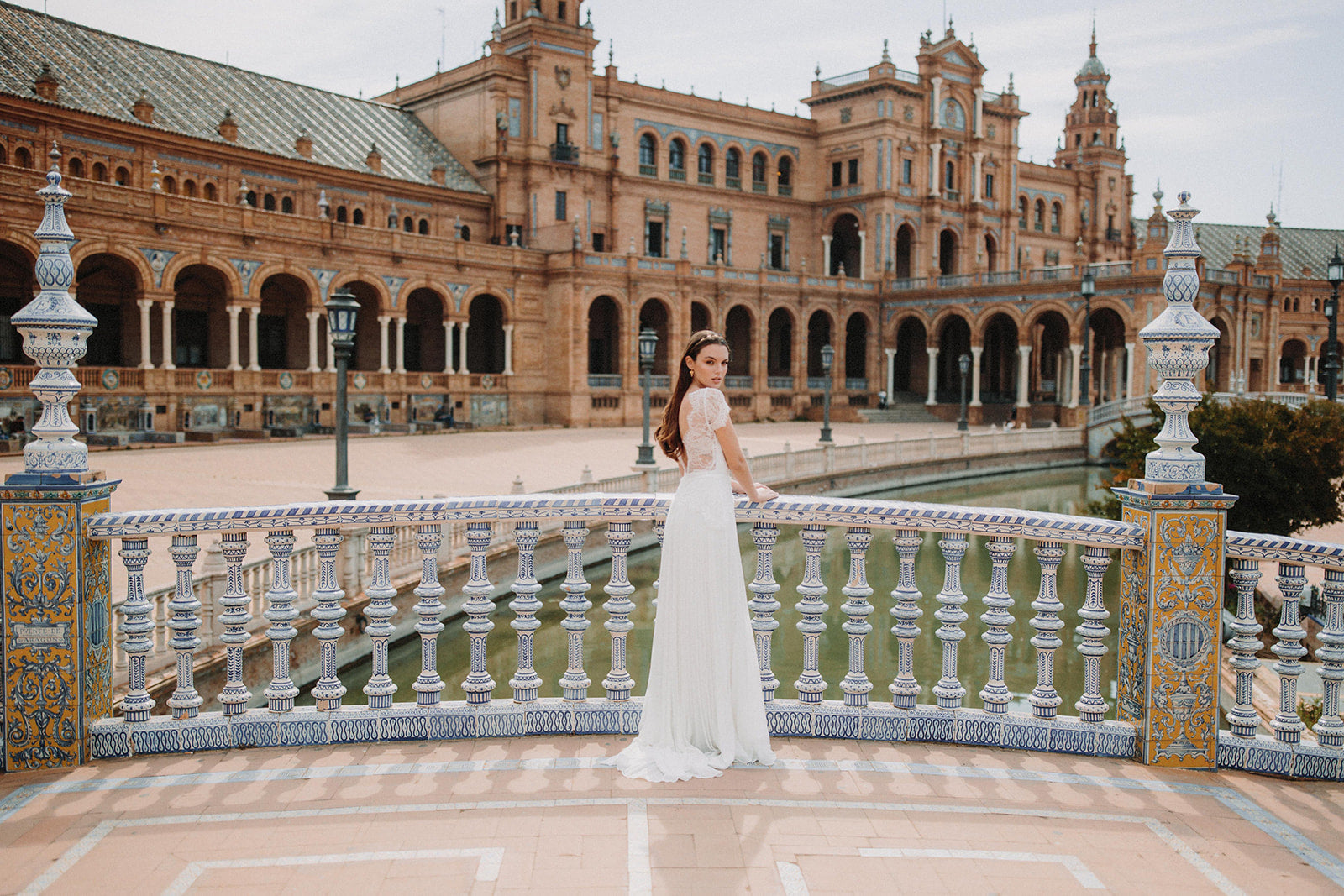 mariée prise en photo à Séville pendant le shooting de Atelier Lilac avec une robe blanche en dentelle et une vigne de cheveux en or