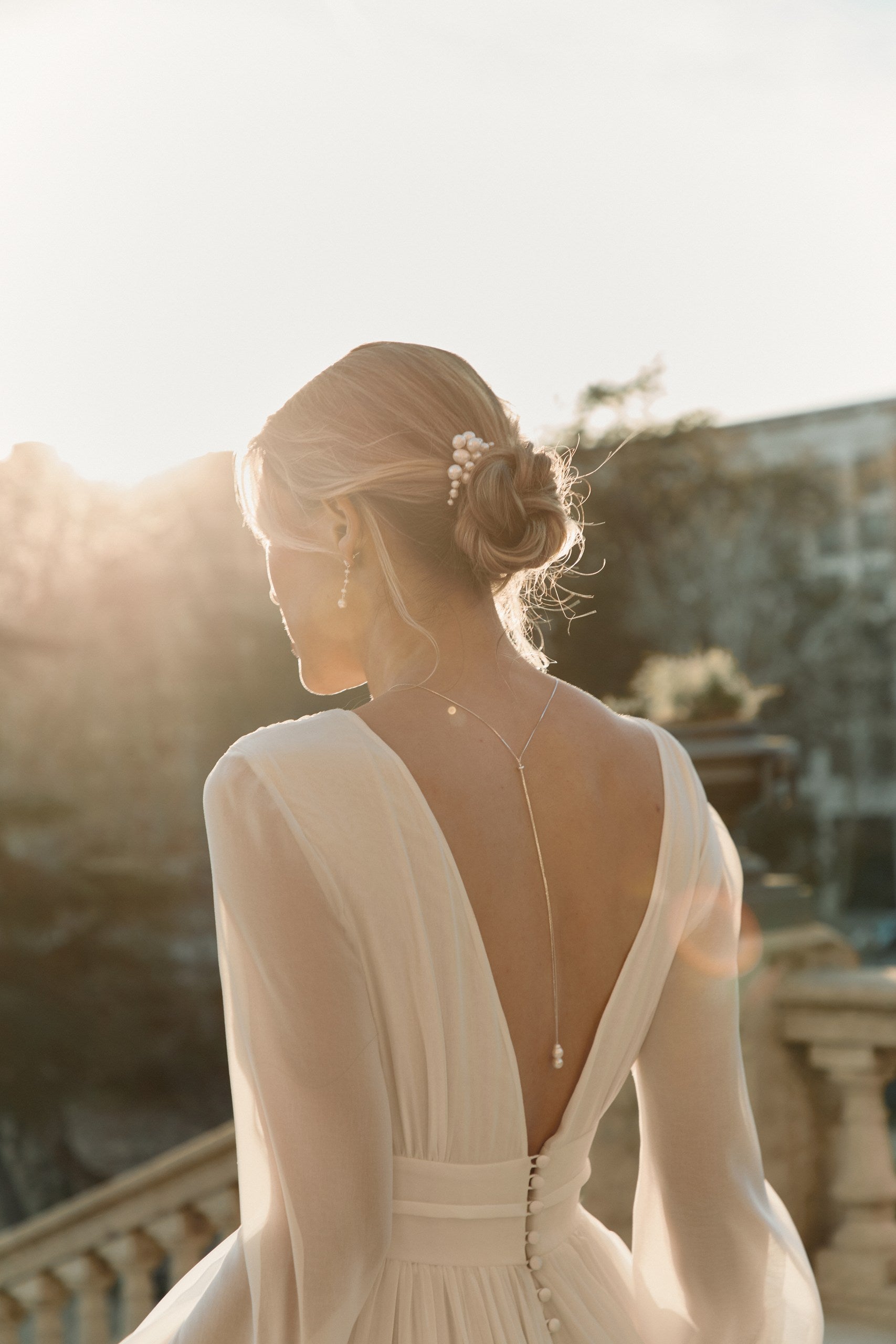 Jeune femme avec un chignon romantique agrémenté de bijoux de perles naturelles 