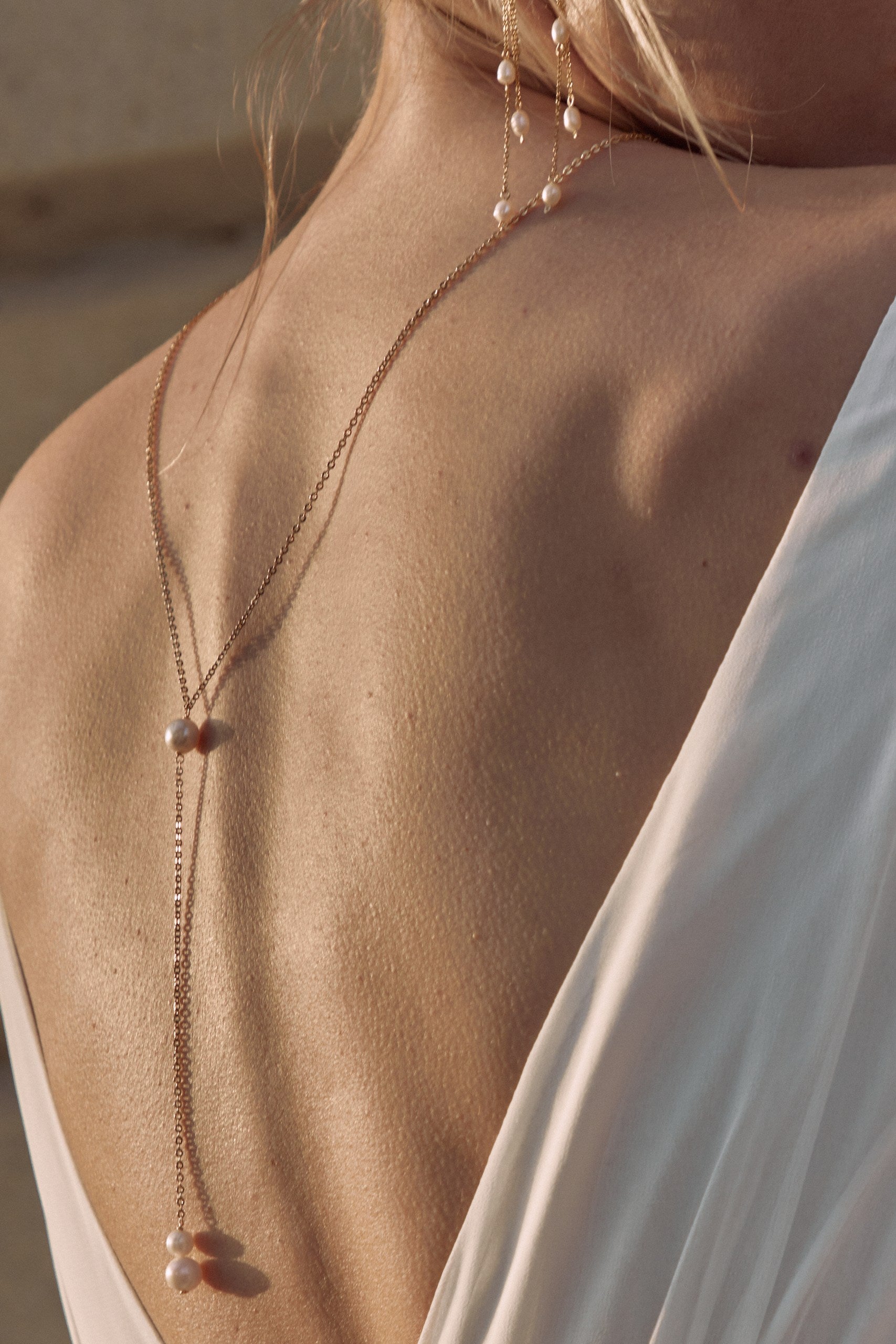 Gros plan du dos d'une femme montrant un collier de dos minimaliste de mariage