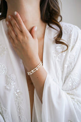 Mariée portant des un bracelet à double rangée en perles naturelles de culture blanche et en perles rocailles blanches