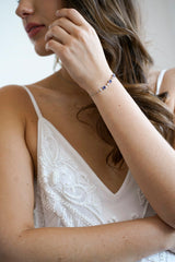 Mariée portant un bracelet argenté avec des pierres bleues idéal pour la tradition quelque chose de bleu
