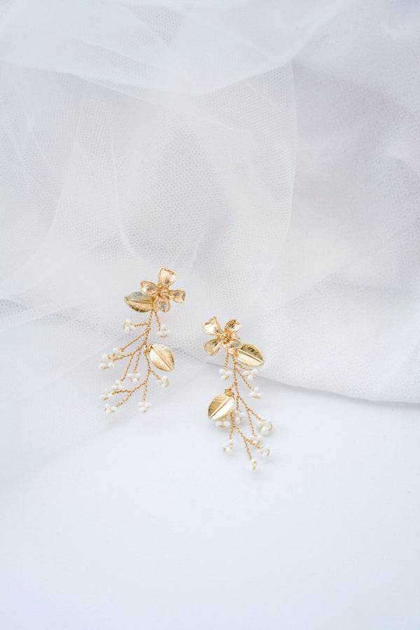 Boucles d'oreilles pendantes en formes de petit bouquet de fleurs dorées avec des perles rocailles blanches