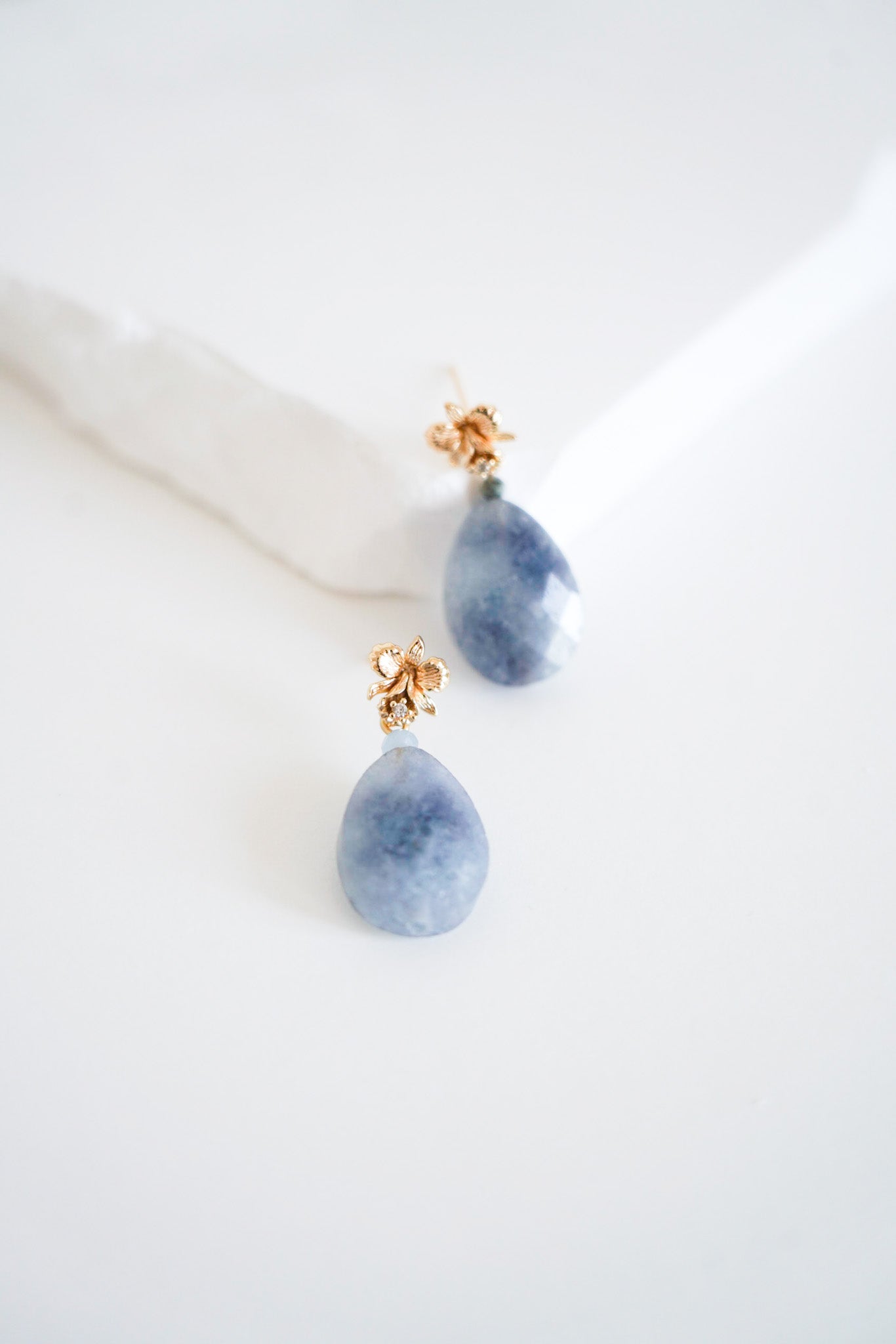 boucles d'oreilles avec une pierre bleu et une attache en or avec un cristal confectionné pour un mariage