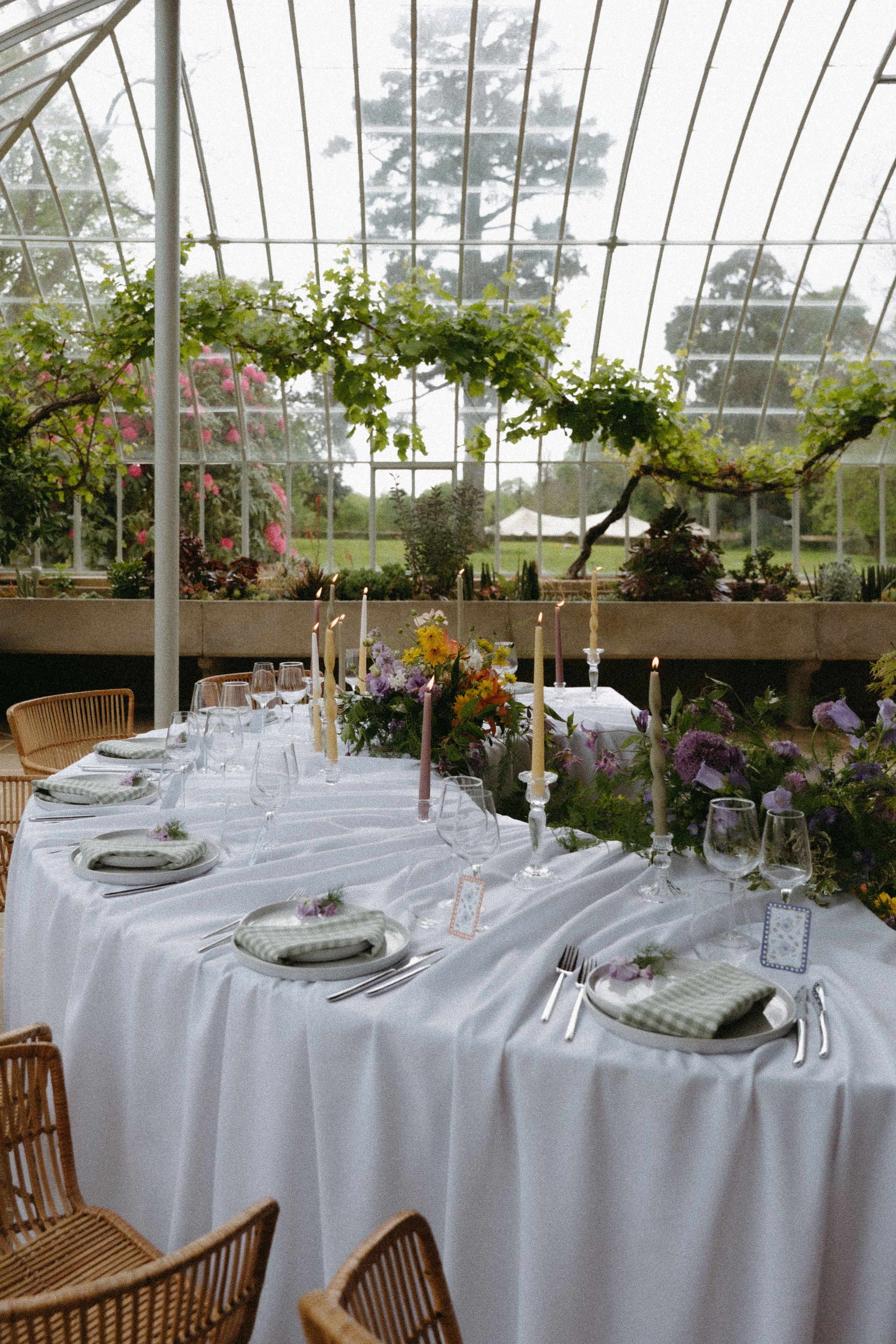 Photo format portrait d'une table de réception de mariage élégant en château, table en arc de cercle, bougies, chandeliers, verdure, fleurs, serre; réception de mariage élégant dans la véranda d'un château, arrangement floral de mariage élégant