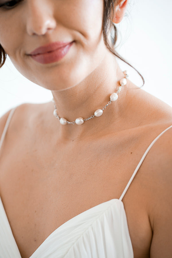 Mariée portant un collier de mariage ras-le fait de perles et de connexions argentés