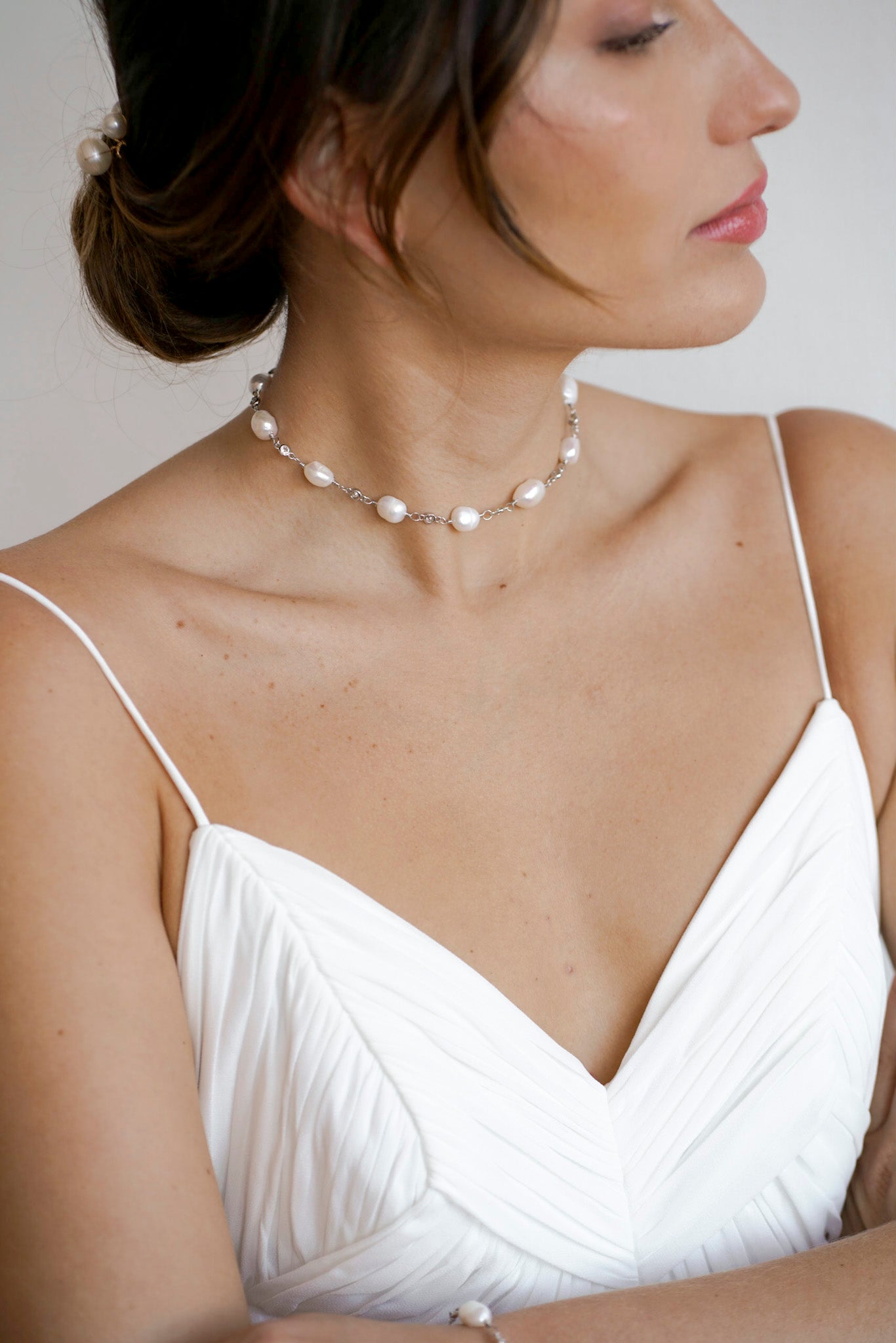 femme en robe de mariée portant un collier de perles naturelles et de connecteurs en cristaux